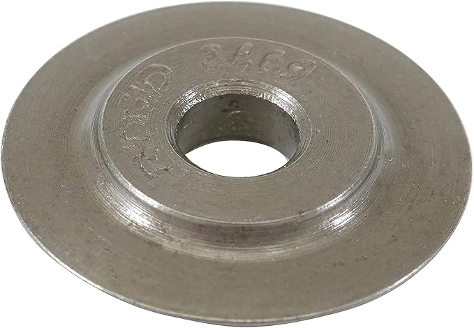 Metallic circular replacement wheel with central hole and embossed text on flat surface.