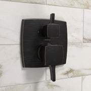 Rubbed bronze square pressure balance valve trim with diverter handle and two rounded control knobs mounted on tile wall.