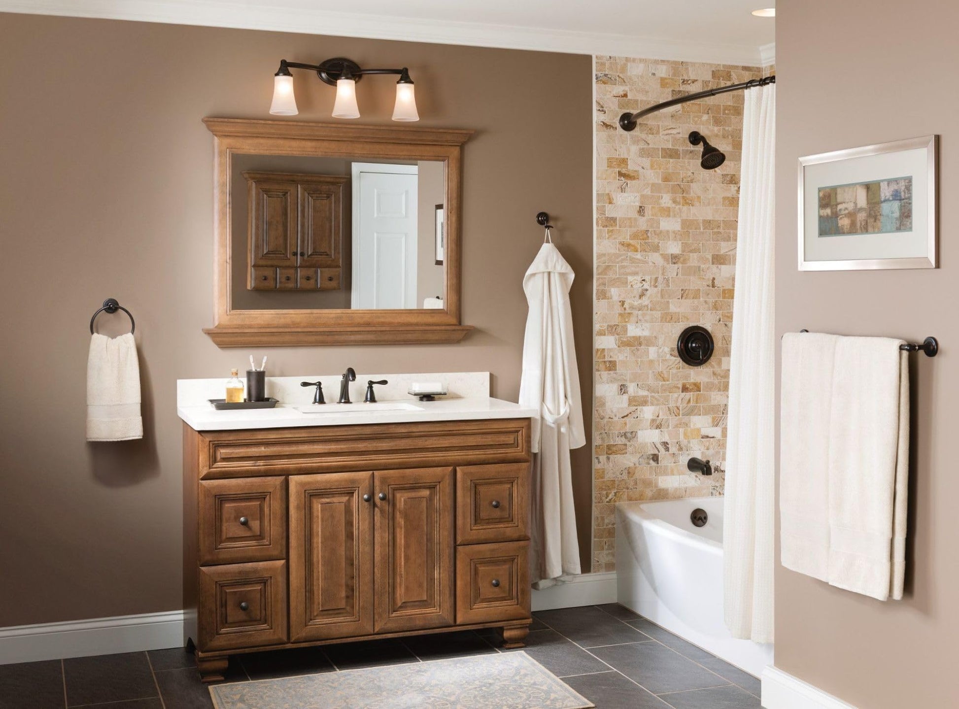 Oil-rubbed bronze bathroom vanity fixture with three frosted glass shades mounted above sink.