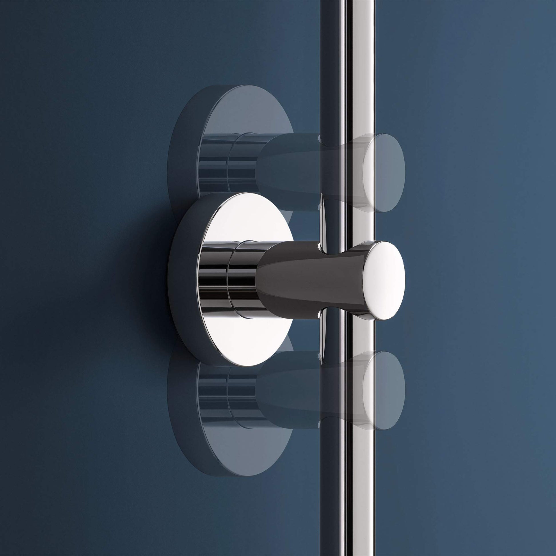 Chrome thermostatic tub/shower valve with round trim plate and hand shower holder on vertical rail.