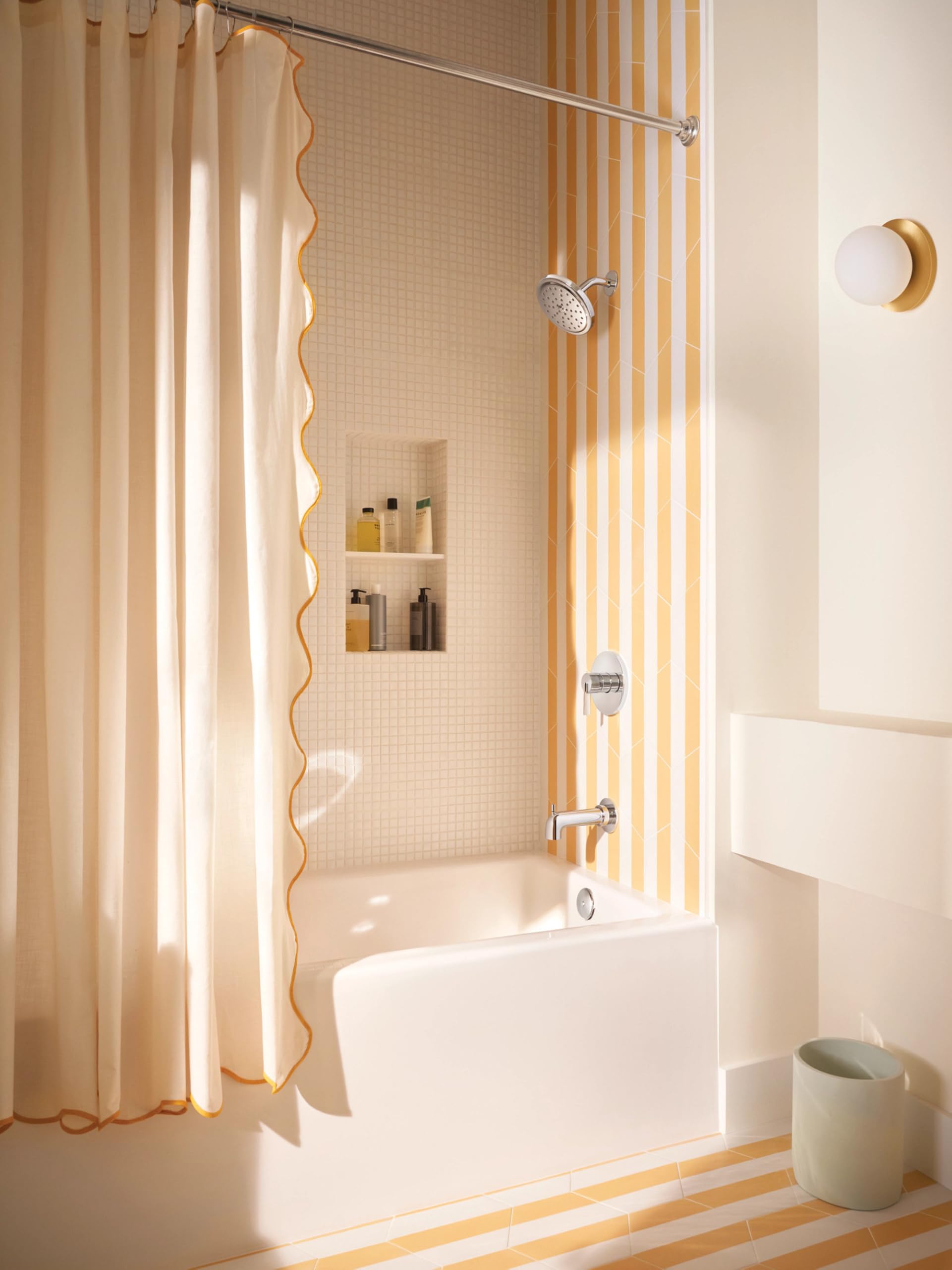 Chrome single-handle tub and shower trim kit mounted on beige tile wall with showerhead and spout visible.