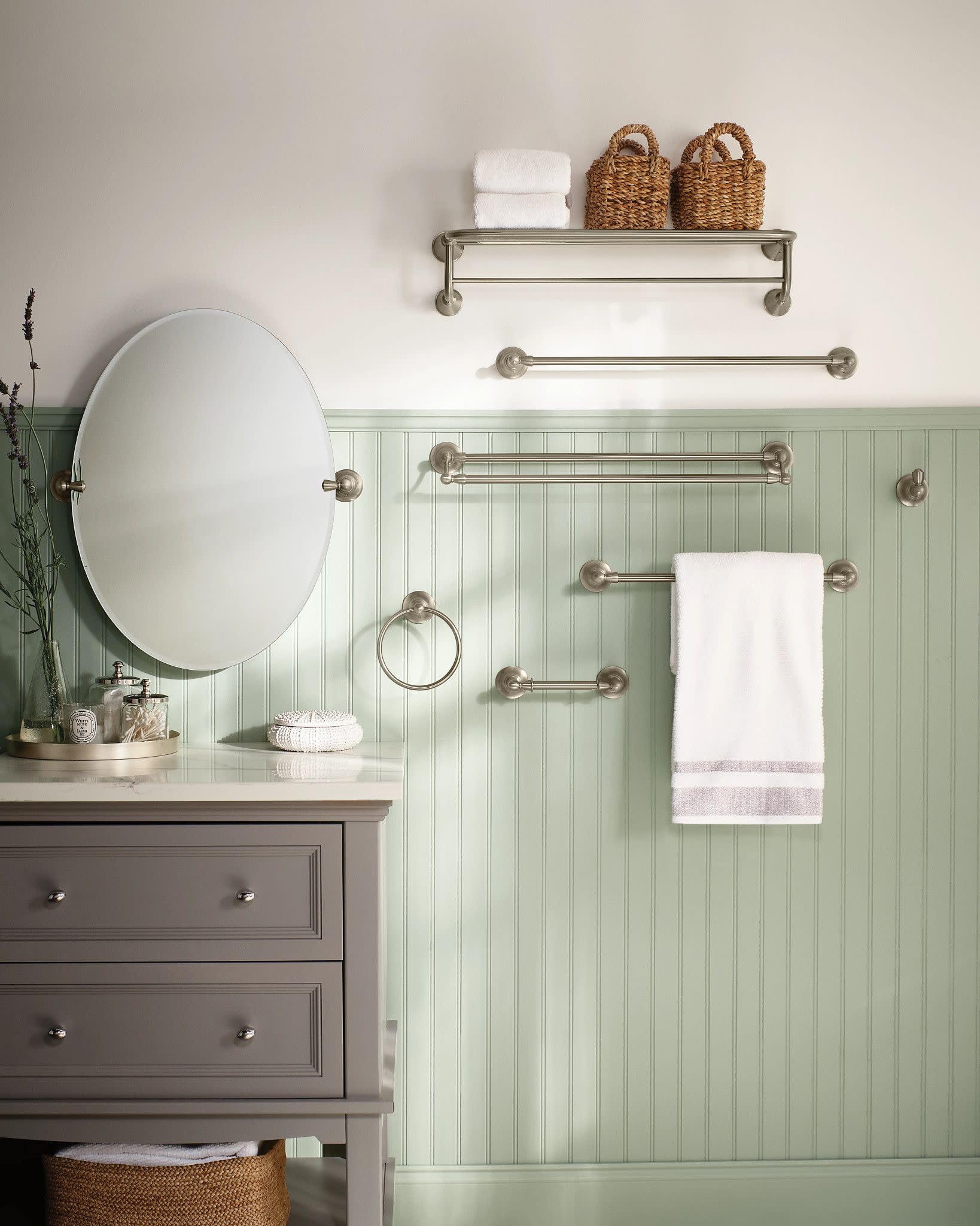 Brushed nickel double towel bar with two parallel horizontal rails and round end caps mounted on green beadboard wall.