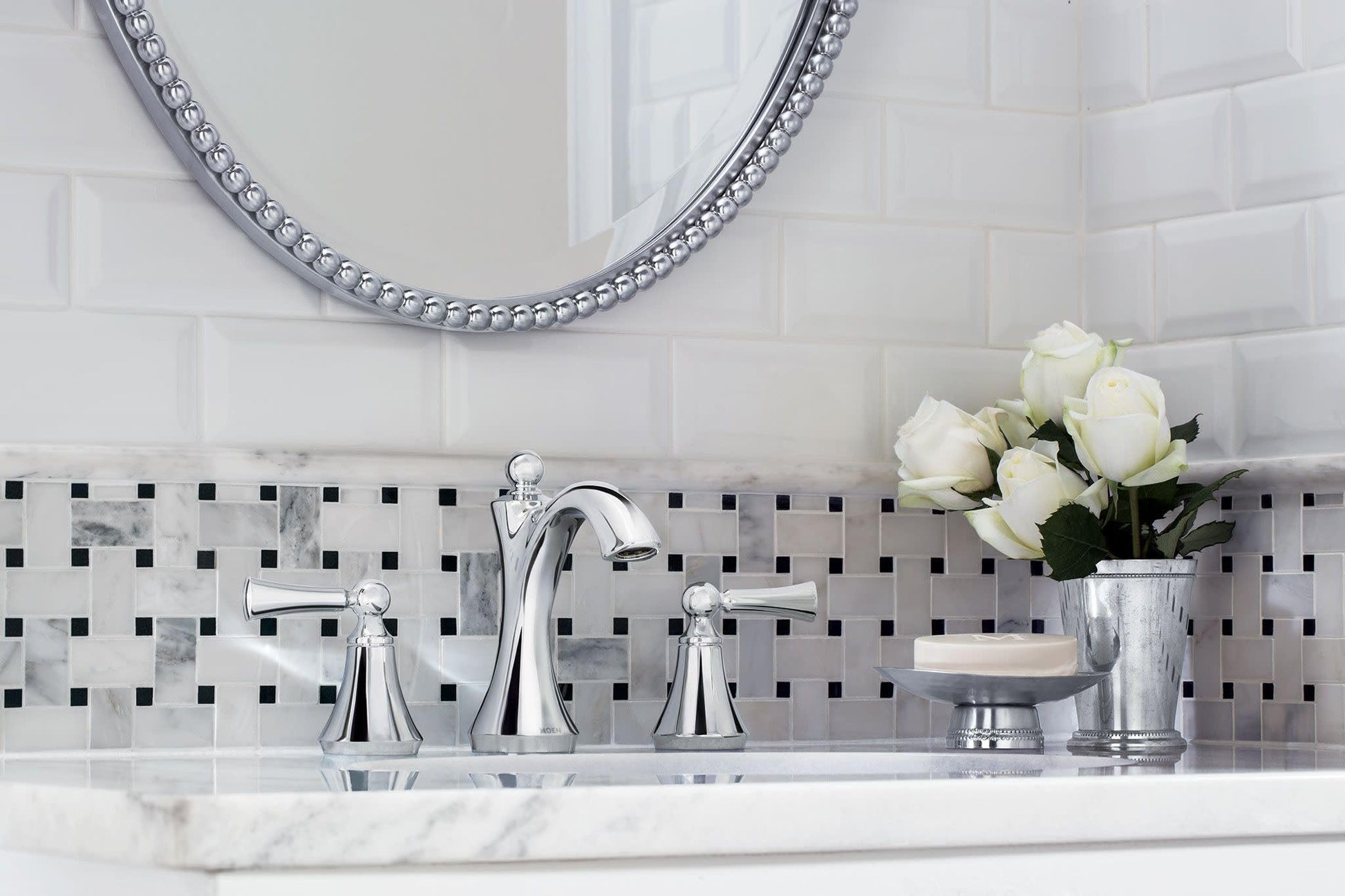 Chrome two-handle widespread bathroom faucet with high arc spout and lever handles installed on marble countertop.