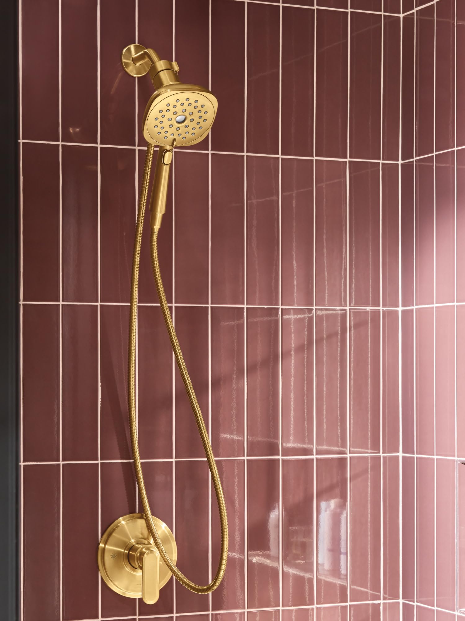 Brushed gold handheld shower head with 5-inch square spray face mounted on wall with flexible hose and valve control.