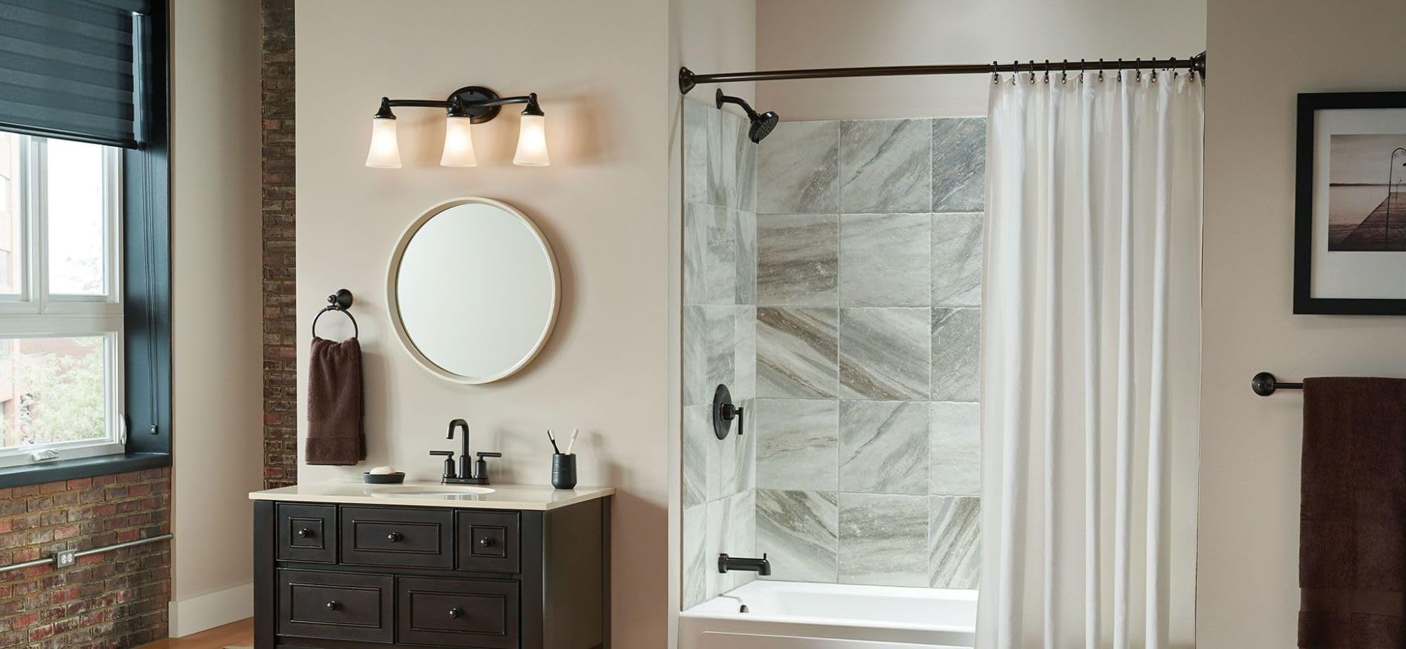 Three-light oil-rubbed bronze vanity fixture with frosted glass shades mounted above bathroom sink.