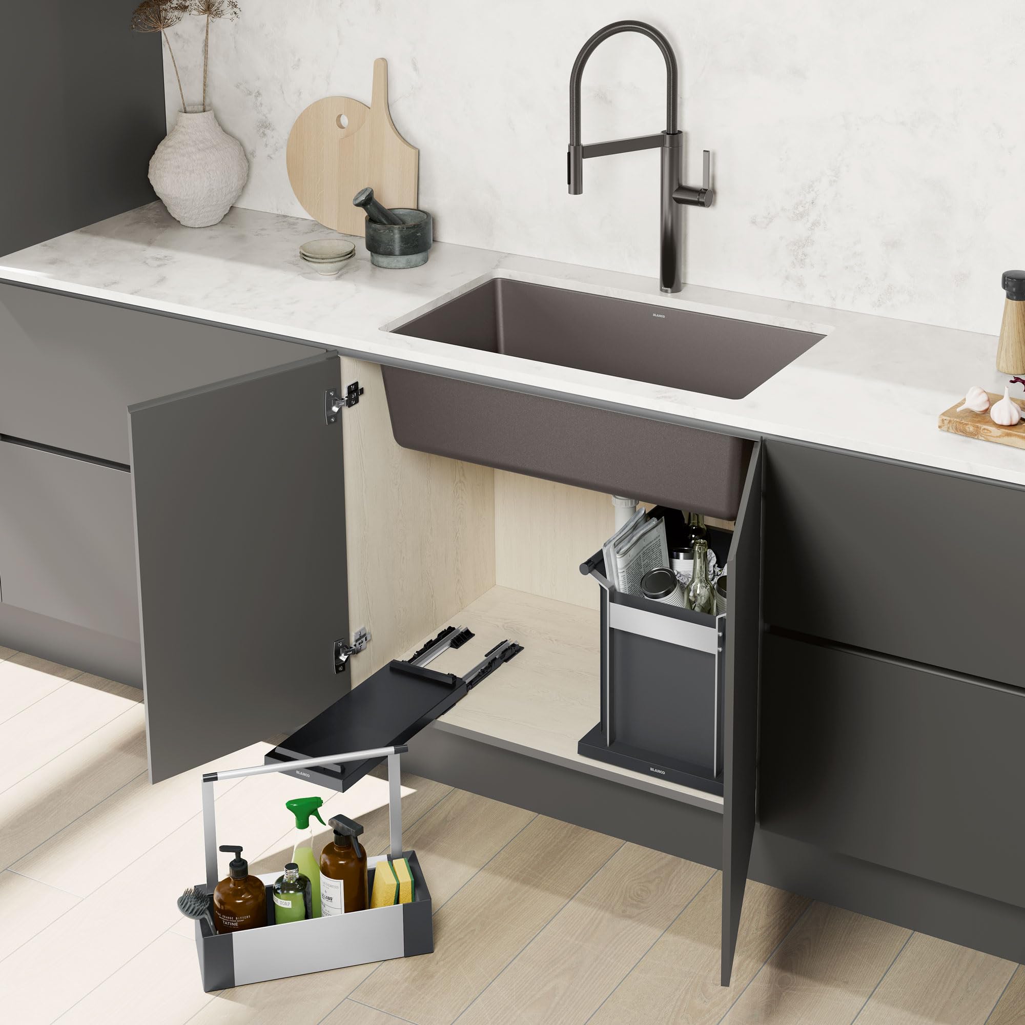 Black pull-out storage caddy with compartments installed under a kitchen sink next to utensil holder.