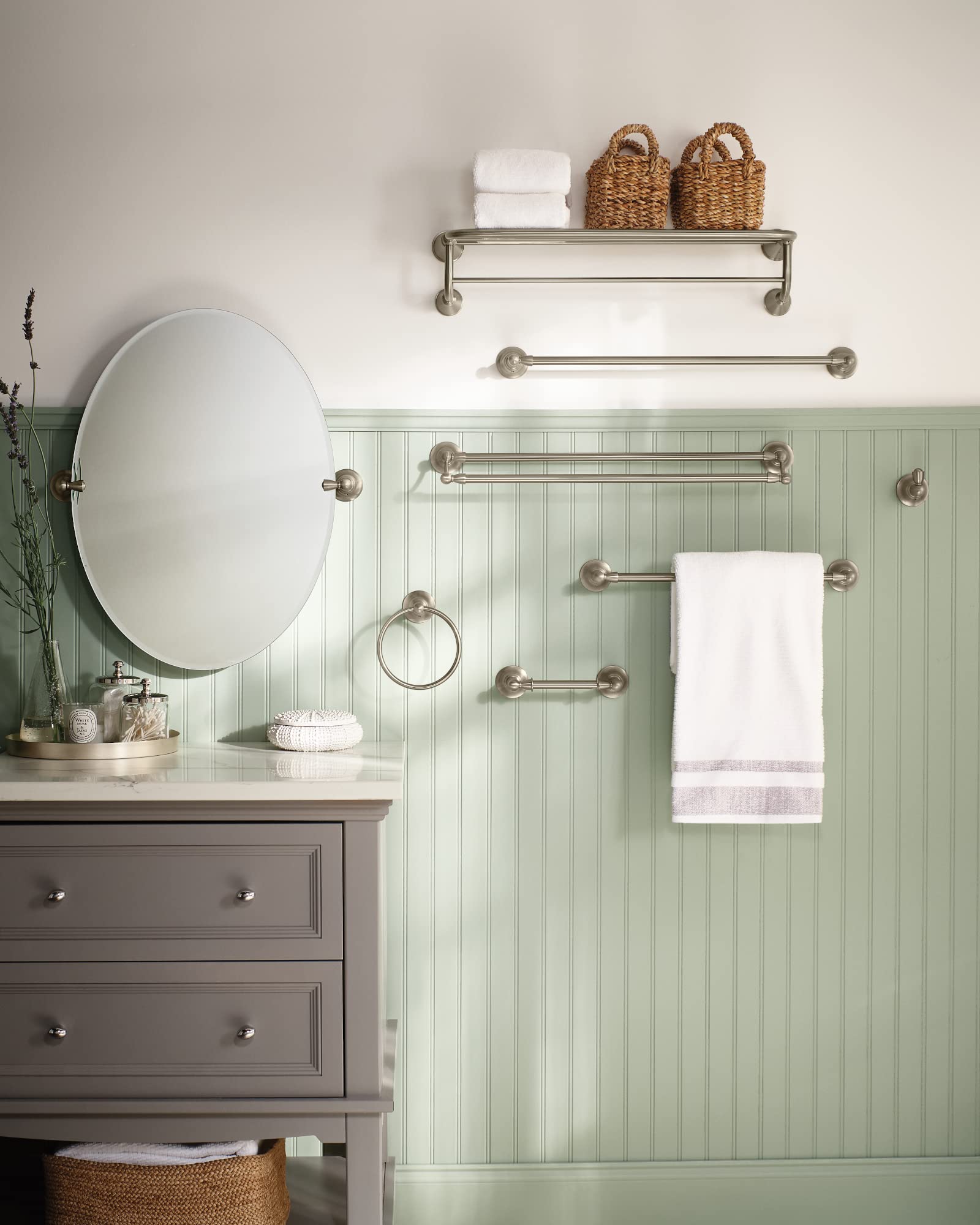 Brushed nickel towel bar with spherical end caps mounted on green beadboard wall, holding white towel.