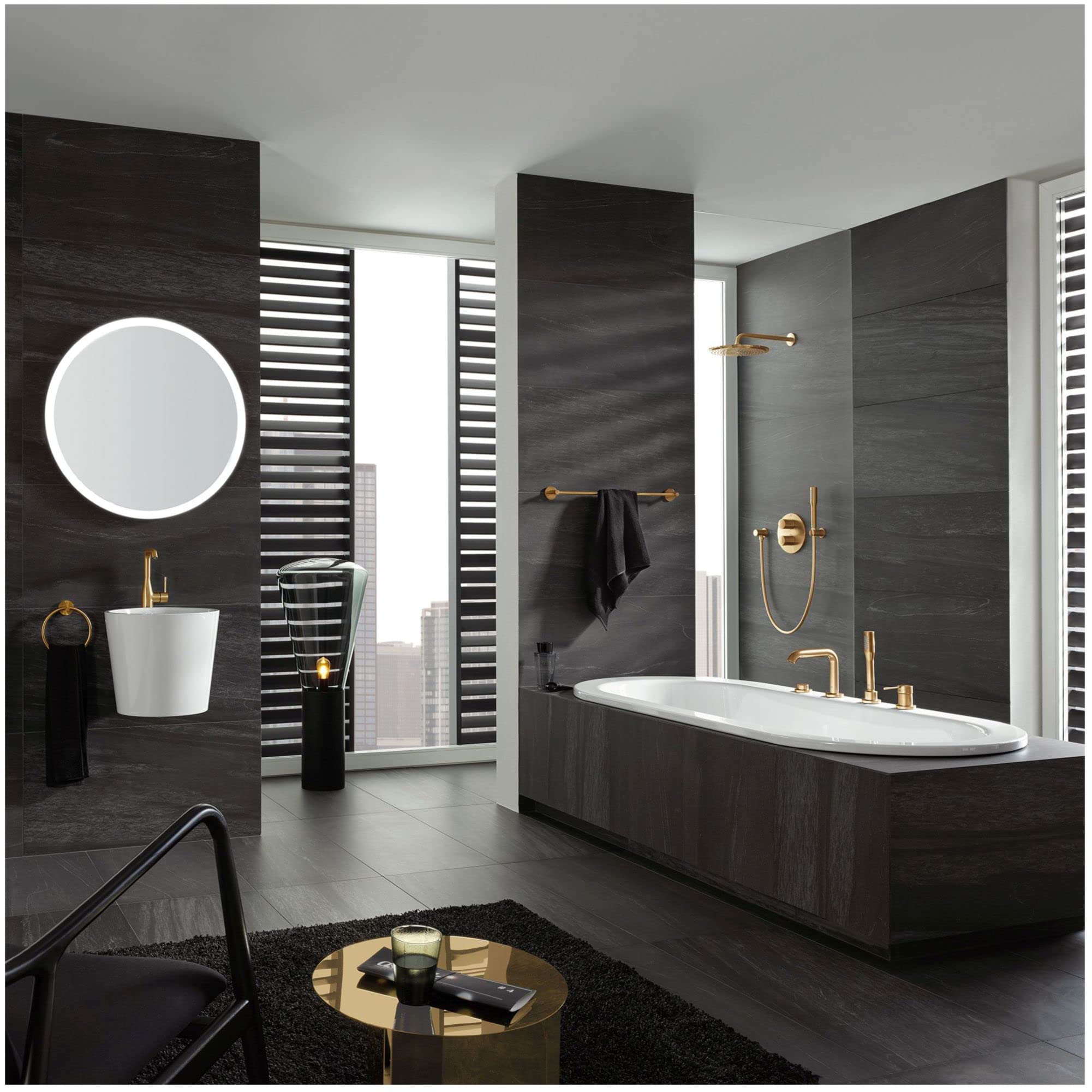 Chrome single-handle roman tub faucet with hand shower mounted on dark tile bathroom wall above white oval bathtub.
