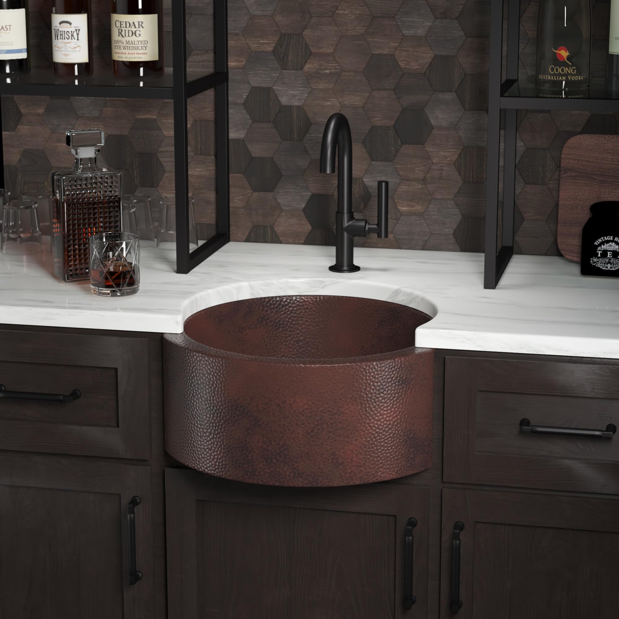 Hammered copper undermount bar sink with textured surface installed in white countertop with black faucet.