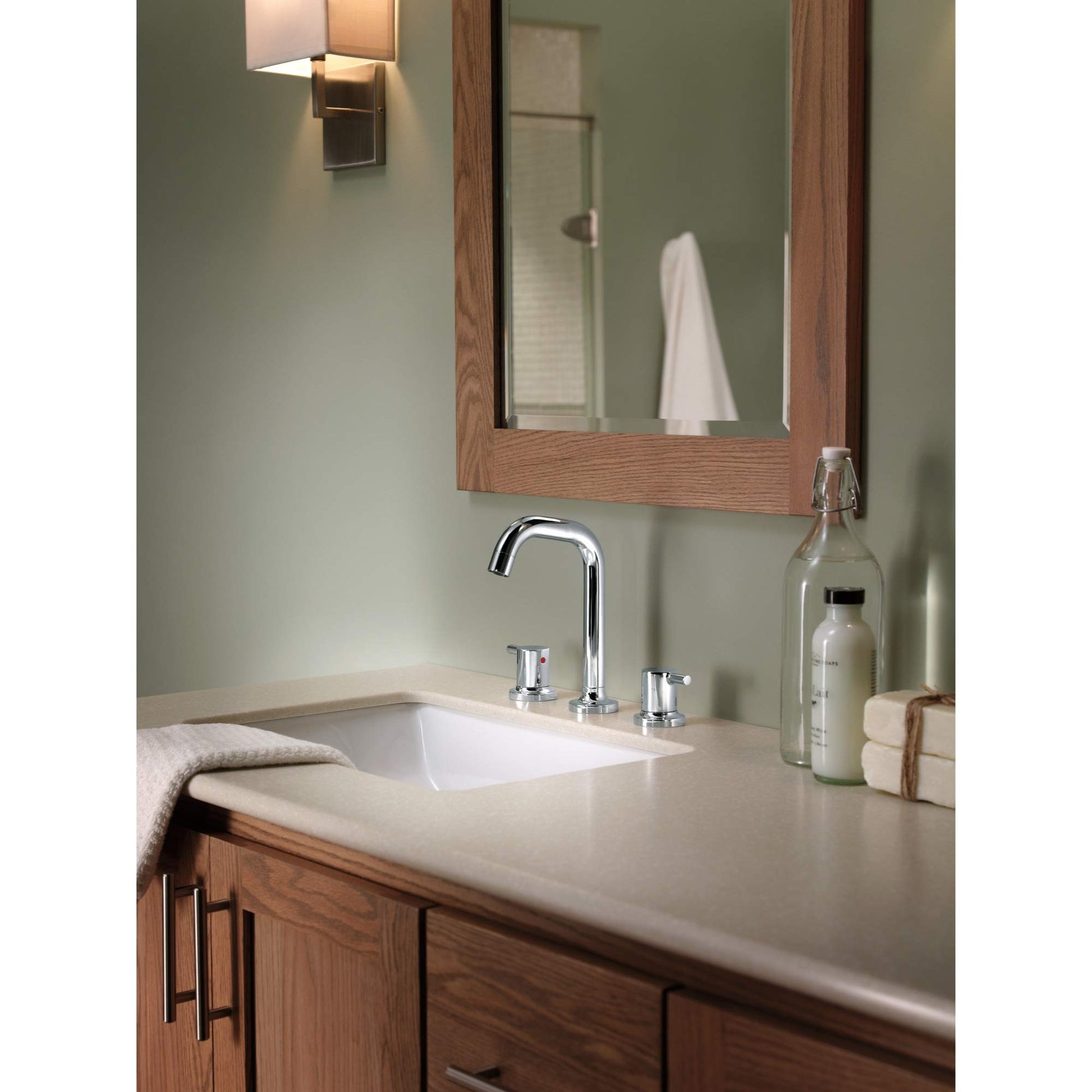 Chrome curved robe hook mounted on bathroom wall above sink vanity.