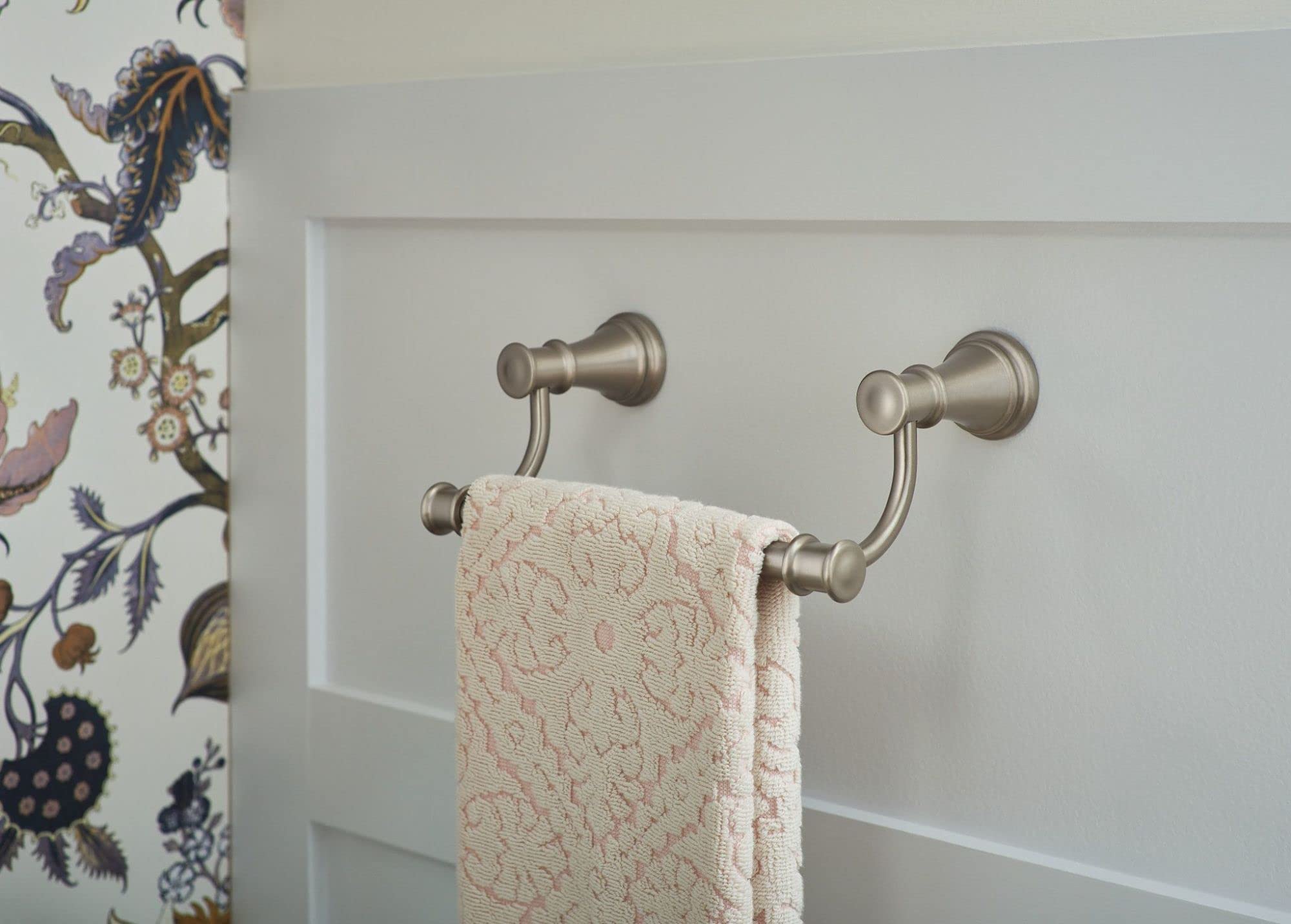 Brushed nickel double towel ring mounted on white wall with cream towel draped across both rails.