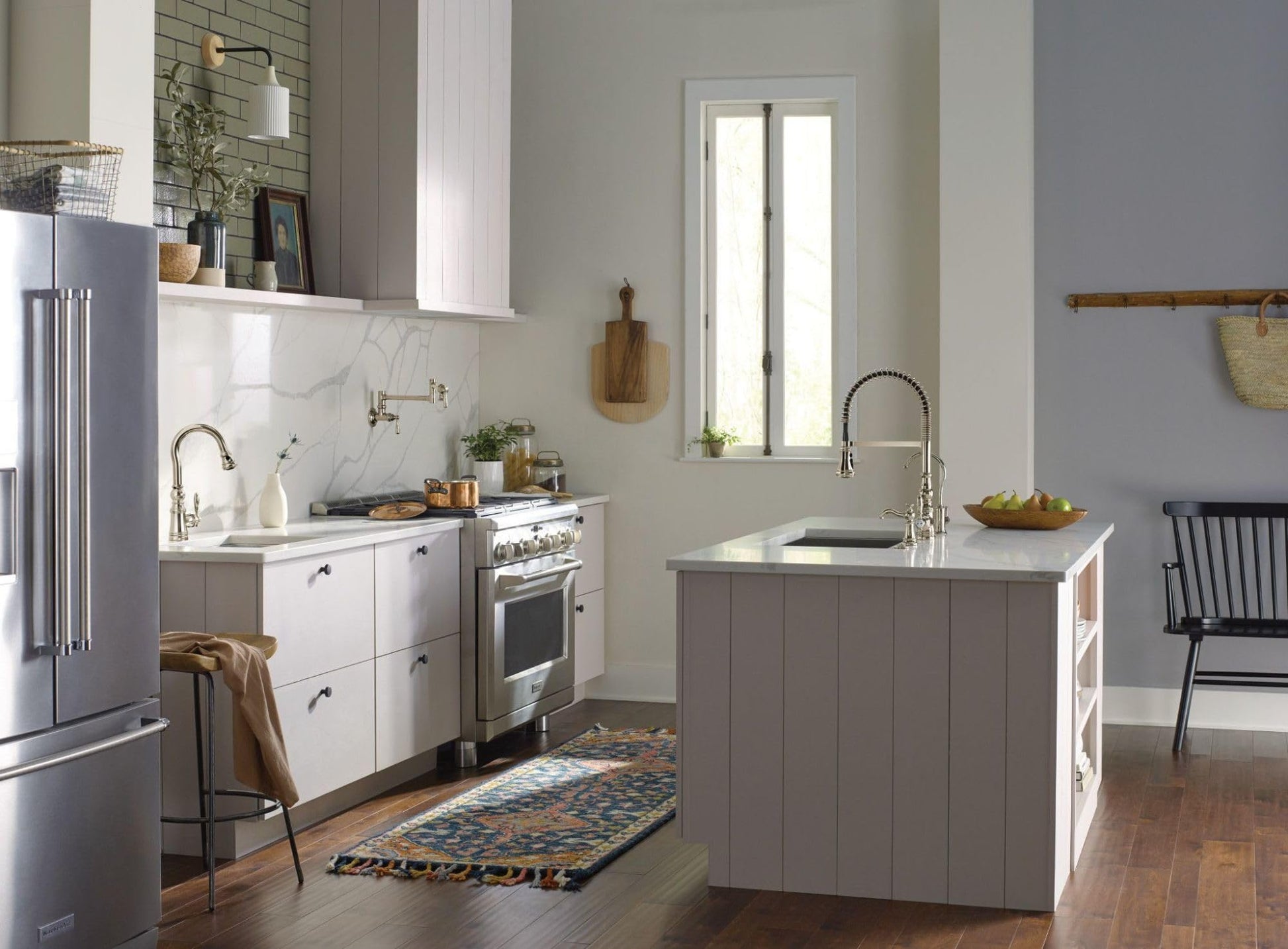 Polished nickel pull-down kitchen faucet with single handle mounted on island sink counter.