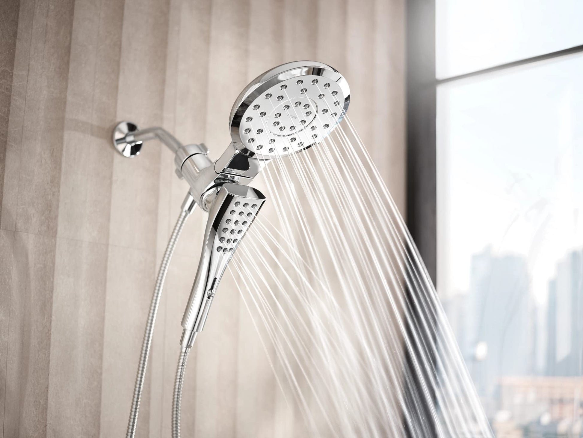 Chrome dual shower head system with overhead round head and handheld wand, both with multiple spray holes.