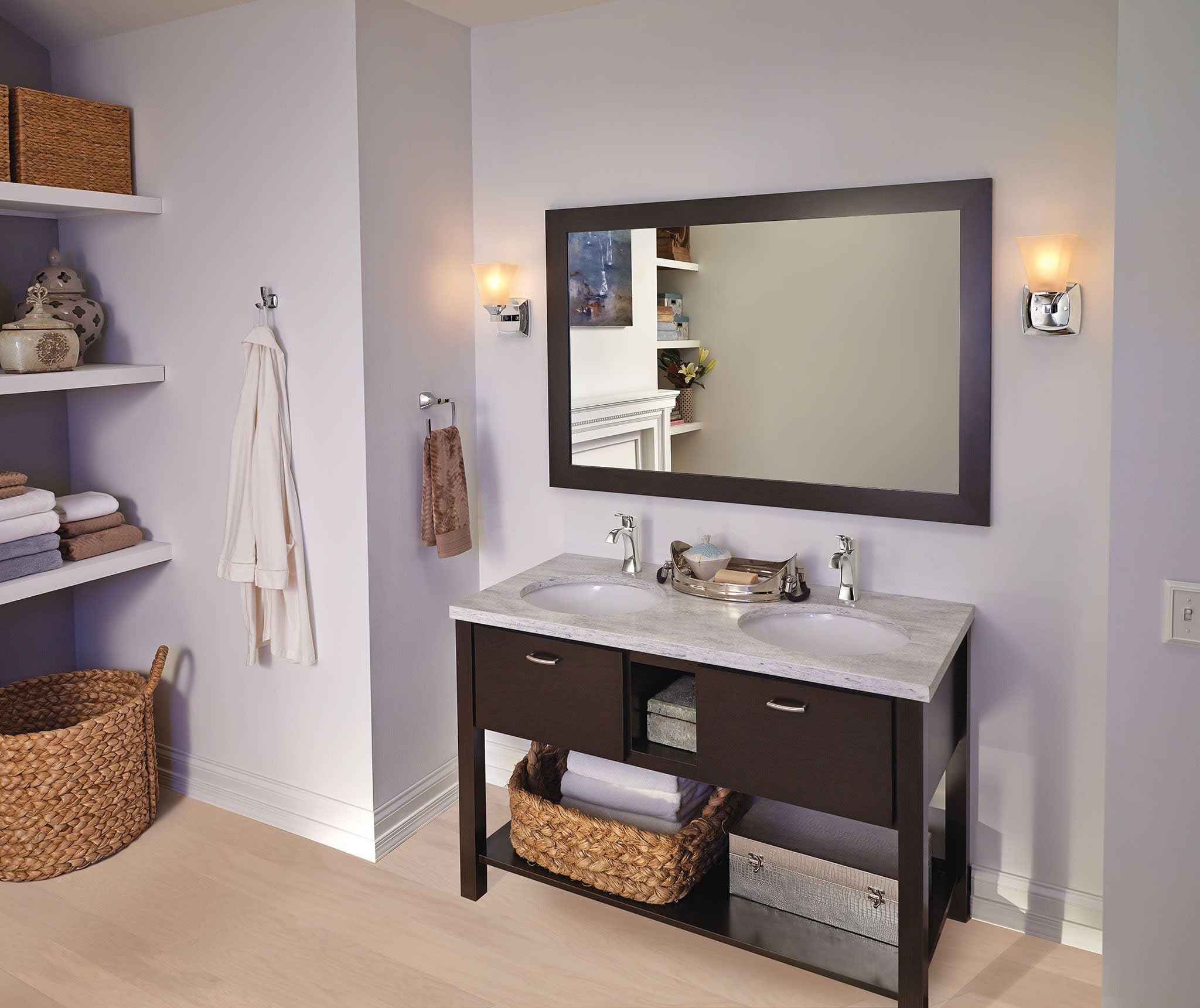 Chrome single-handle bathroom sink faucet mounted on marble countertop with dark vanity and mirror.