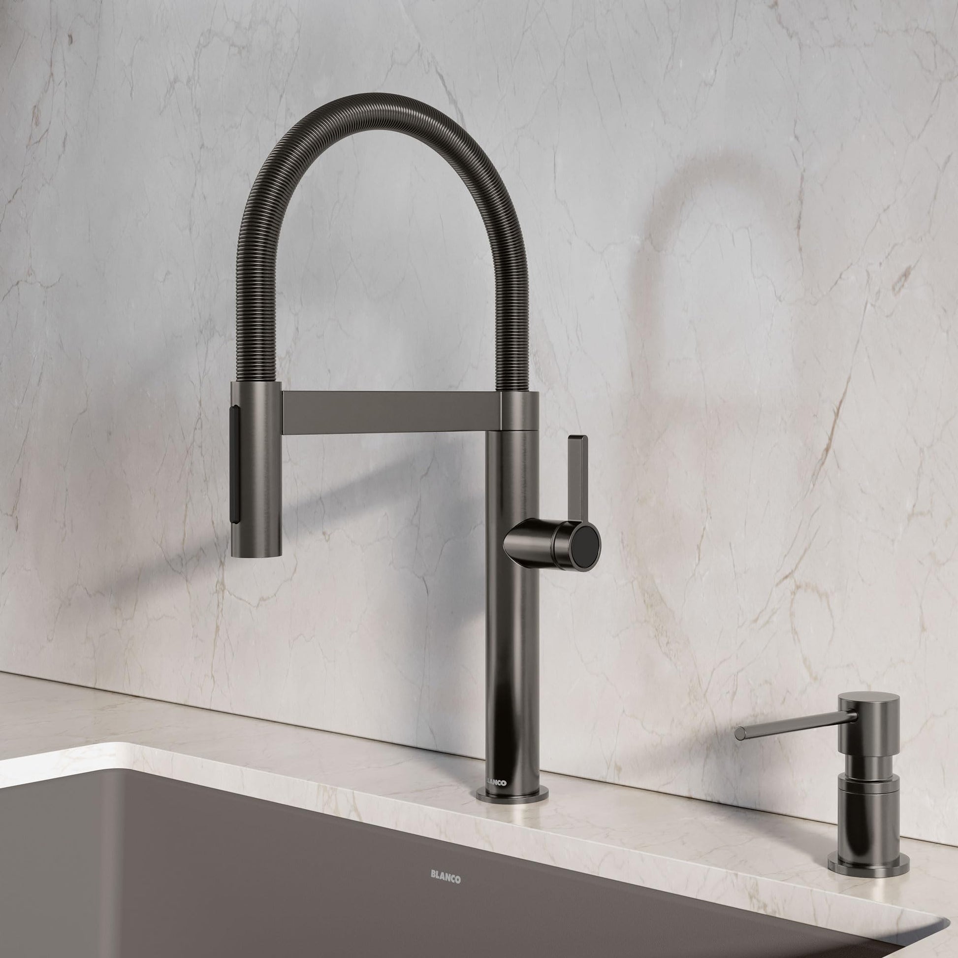 Satin dark steel pull-down kitchen faucet with flexible hose, high arc spout, and matching soap dispenser on marble counterto