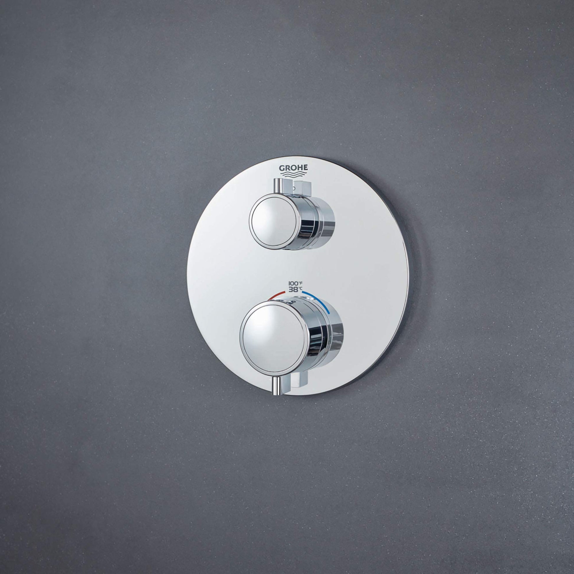 Chrome thermostatic valve trim with round white escutcheon plate and two circular handles mounted vertically.