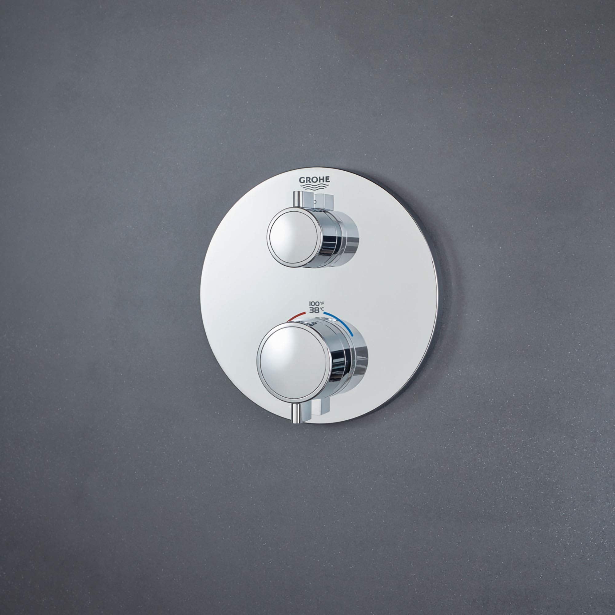 Chrome thermostatic valve trim with round white escutcheon plate and two circular handles mounted vertically.