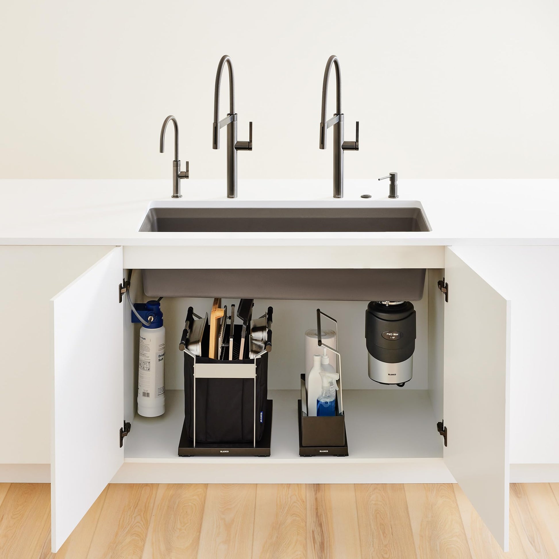 Satin dark steel beverage faucet with curved spout and side lever handle mounted above rectangular sink basin.