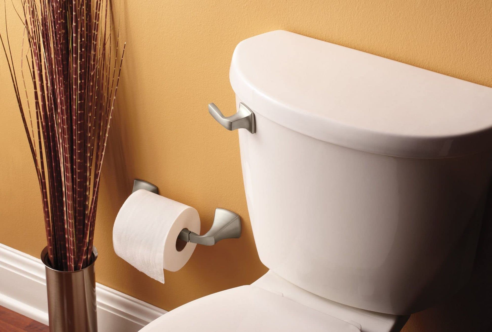 Brushed nickel lever handle mounted on white toilet tank.