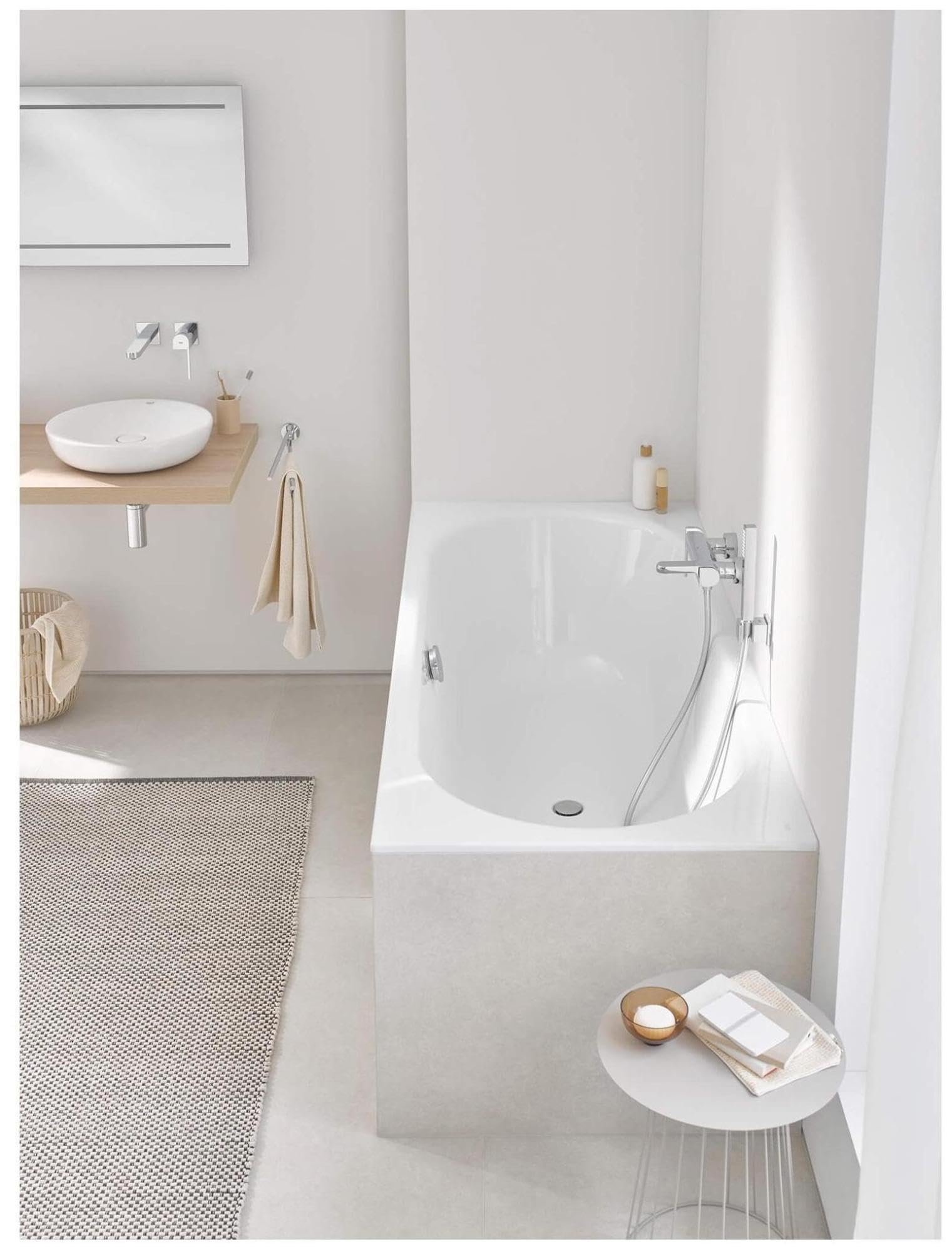 Matte black wall-mounted hand shower holder installed above bathtub in modern bathroom.