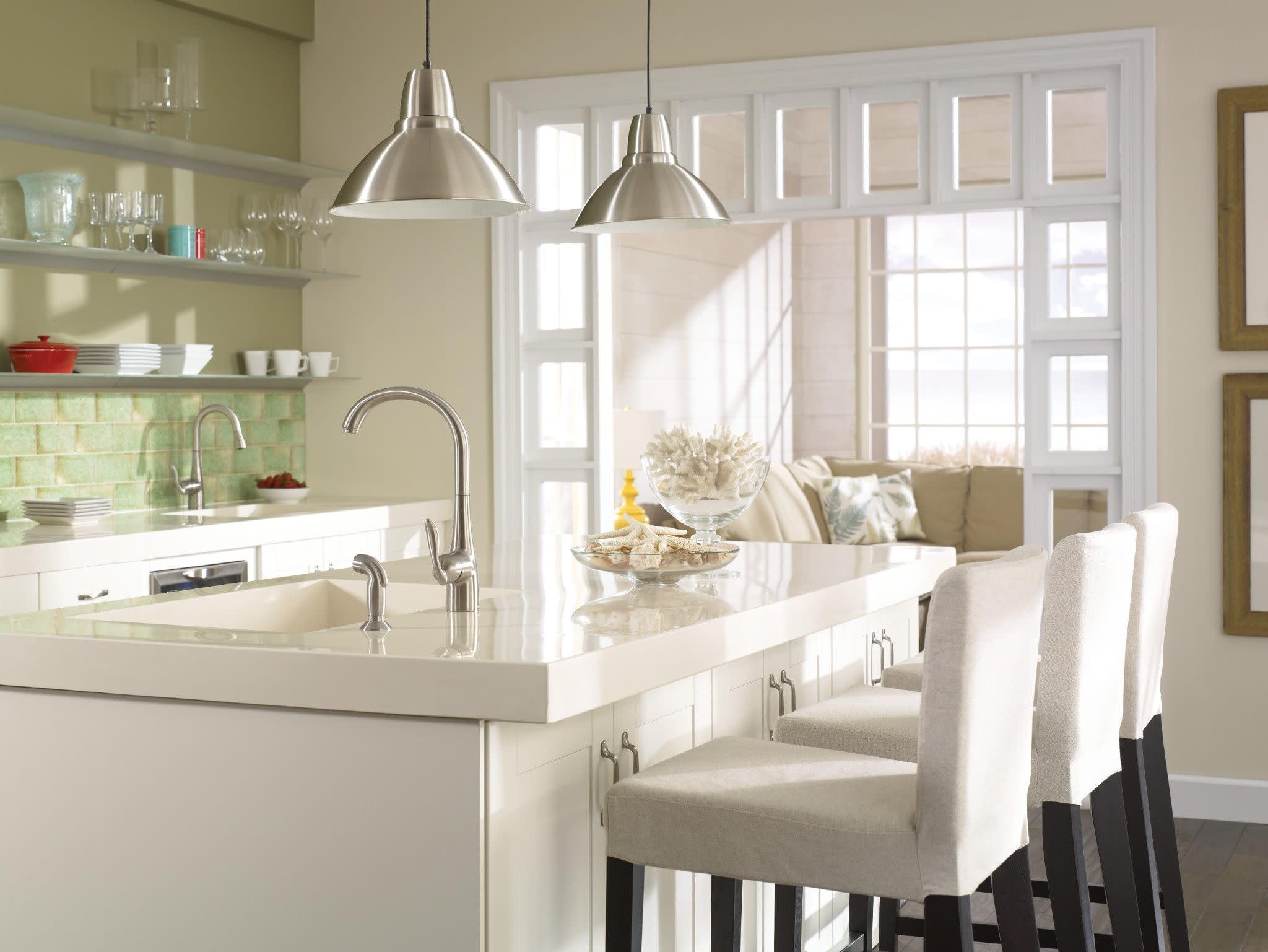Stainless steel single-handle high arc kitchen faucet with curved spout and side spray mounted on white countertop sink.