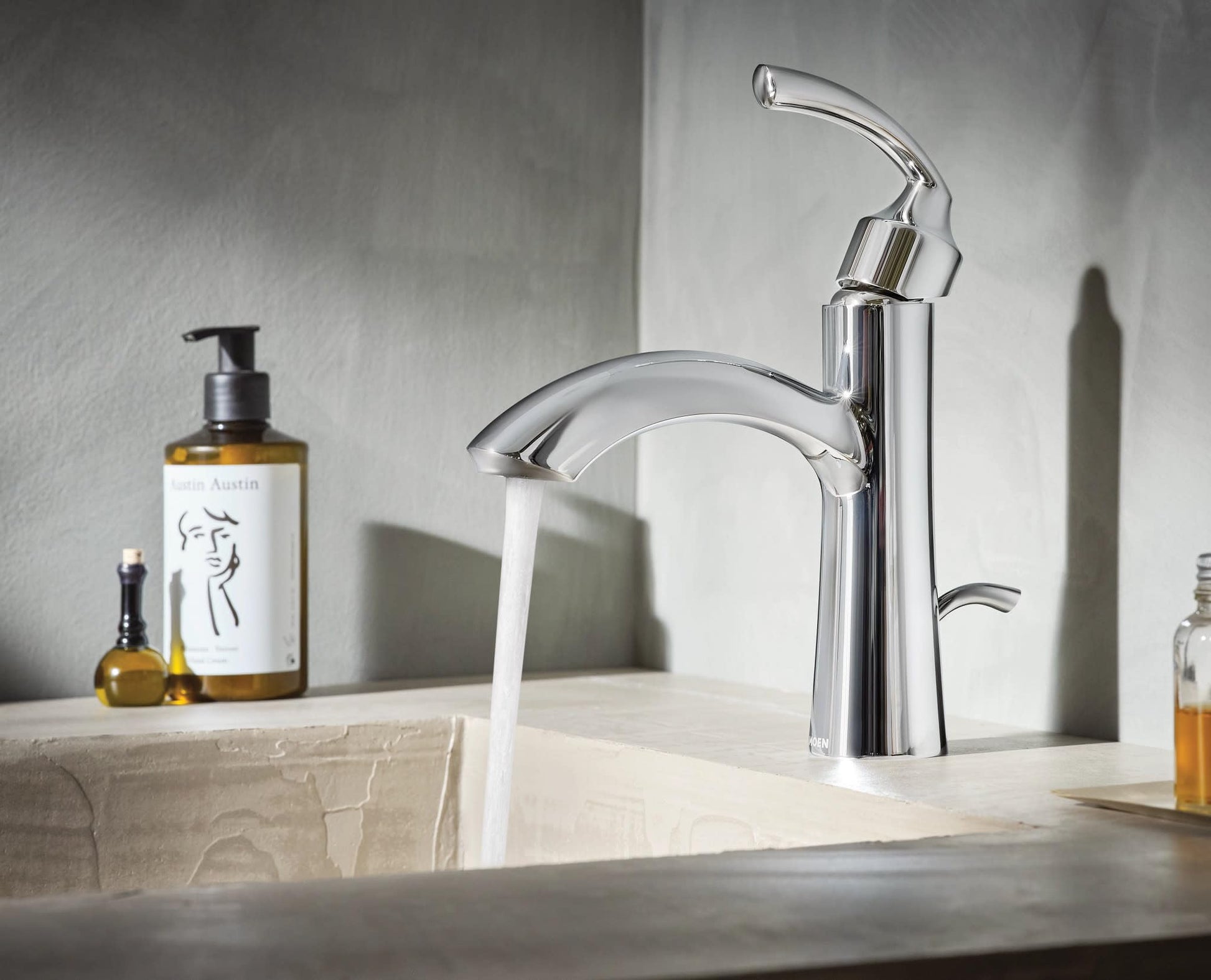 Chrome single-handle bathroom sink faucet with curved spout and lever handle installed on countertop.