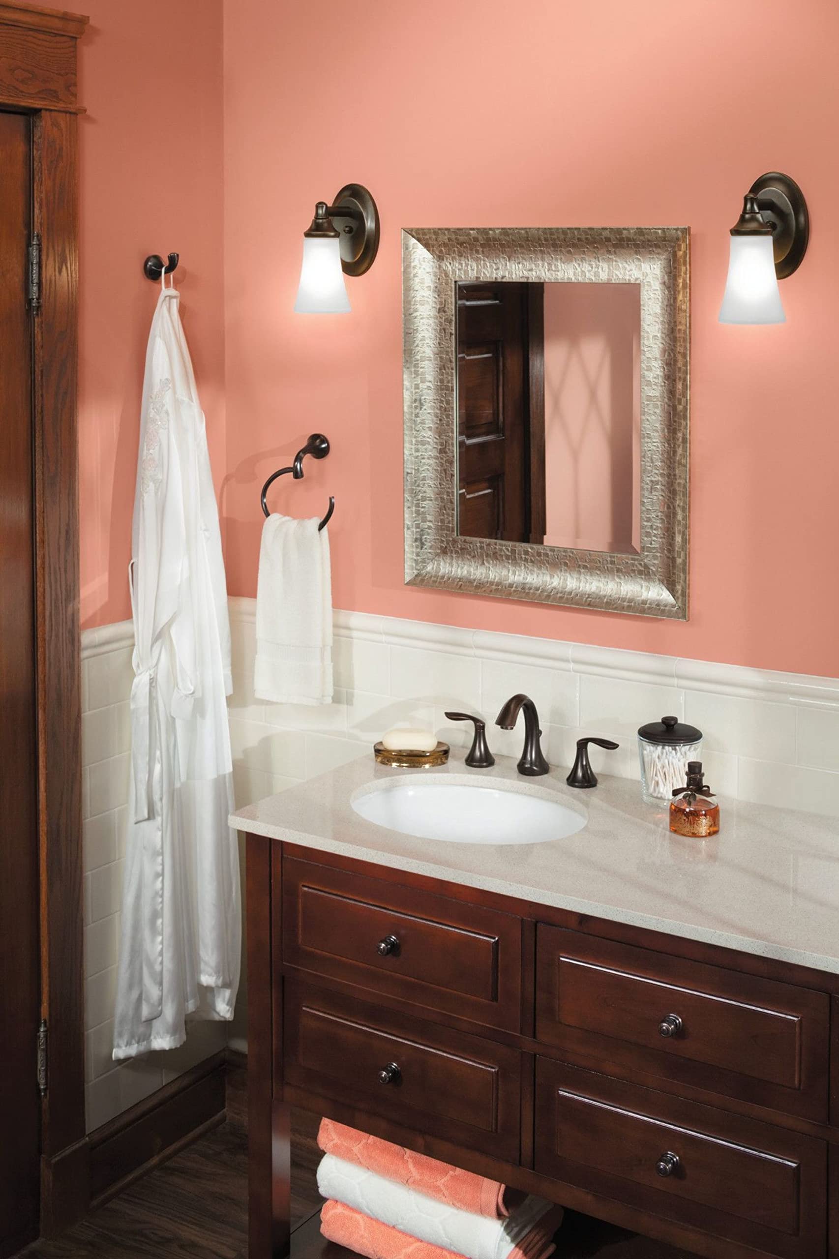 Oil-rubbed bronze towel ring mounted on bathroom wall with white towel hanging from it.