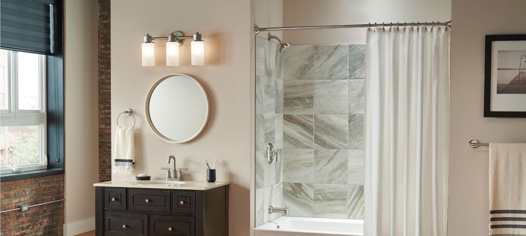 Brushed nickel wall-mounted towel ring installed beside bathroom vanity mirror.