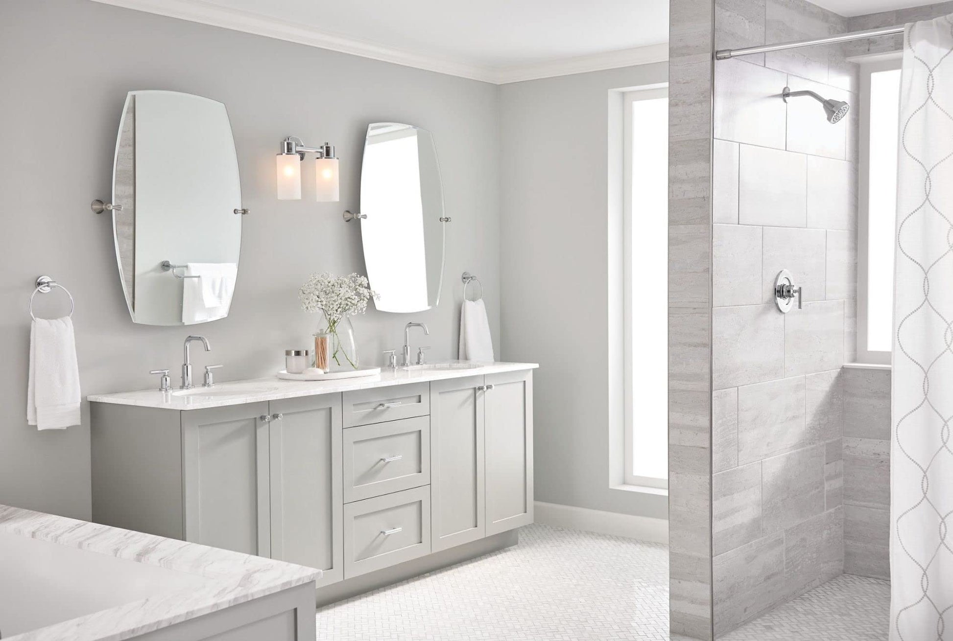 Chrome two-handle deck-mounted faucet installed on bathroom vanity counter with white sink.