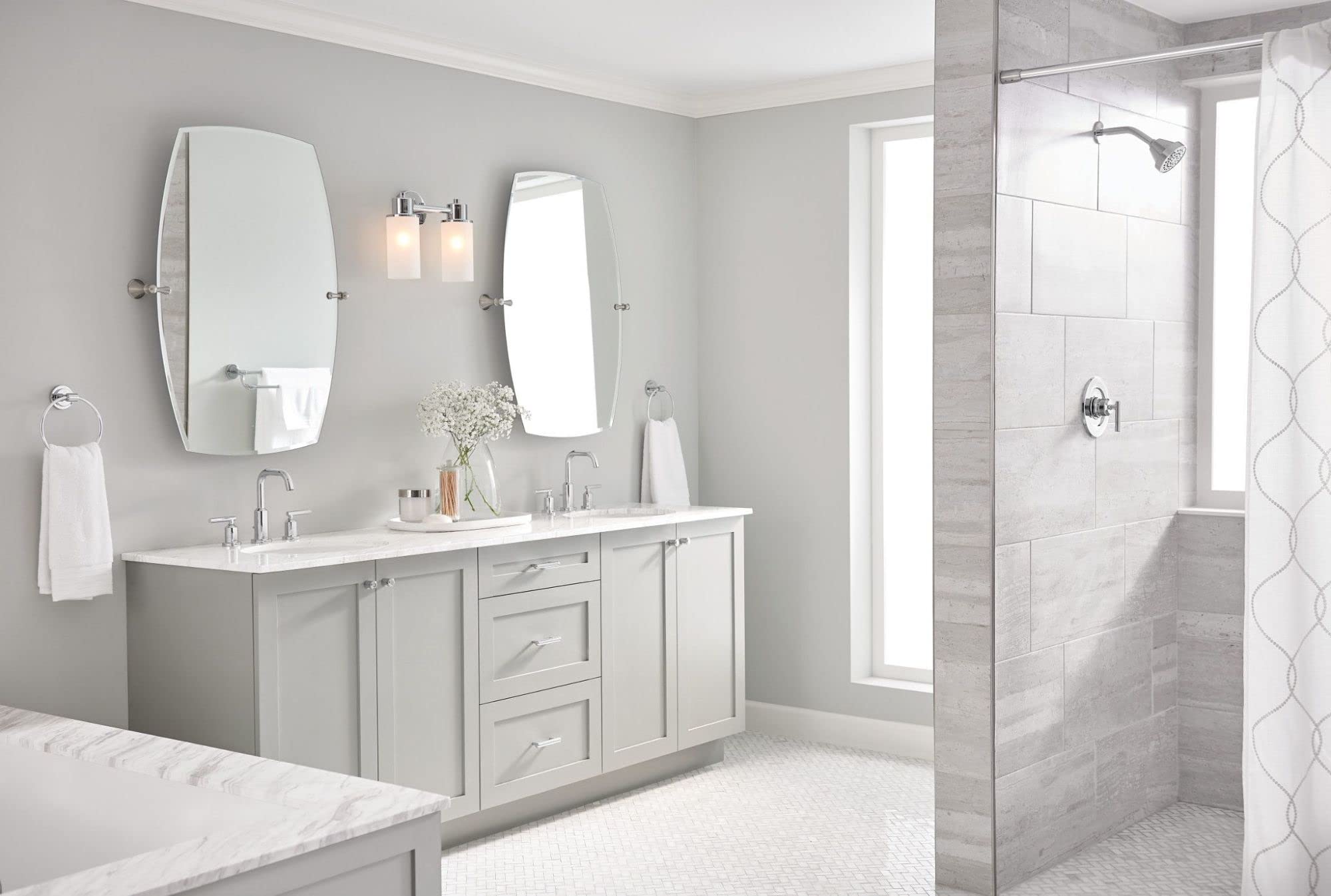 Chrome two-handle deck-mounted faucet installed on bathroom vanity counter with white sink.