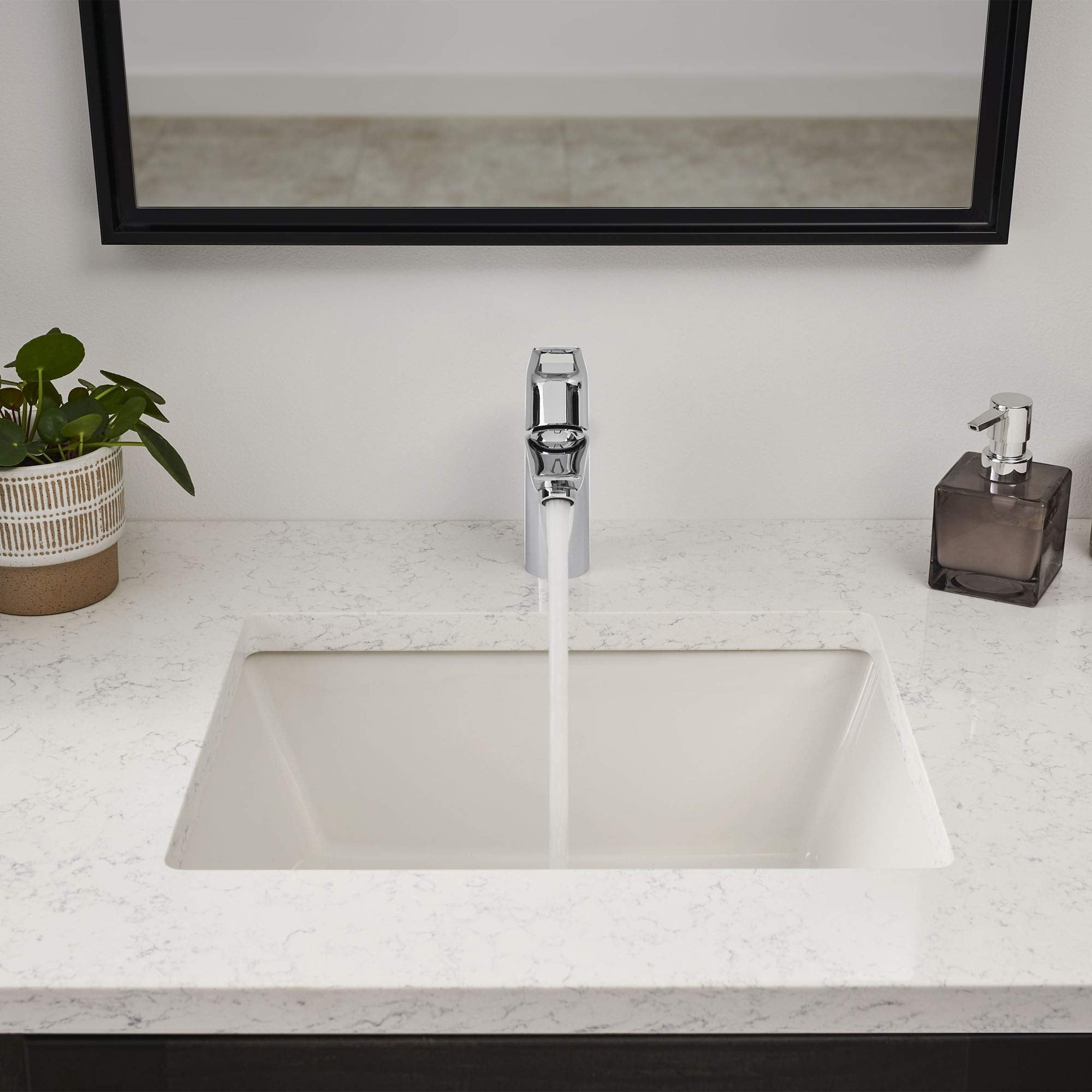 Chrome single-handle bathroom faucet with tall spout installed on marble countertop above rectangular white sink.