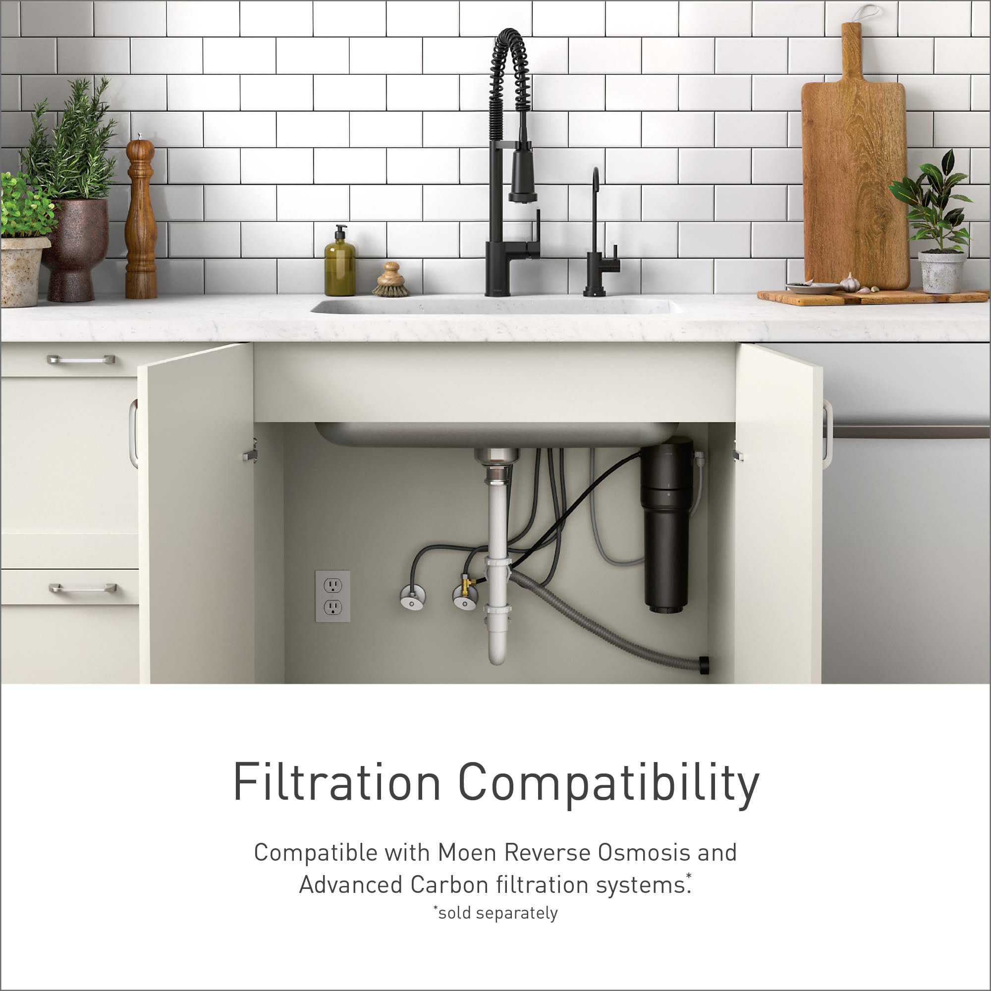 Matte black traditional drinking water faucet with pulldown sprayer installed on white subway tile backsplash above sink.