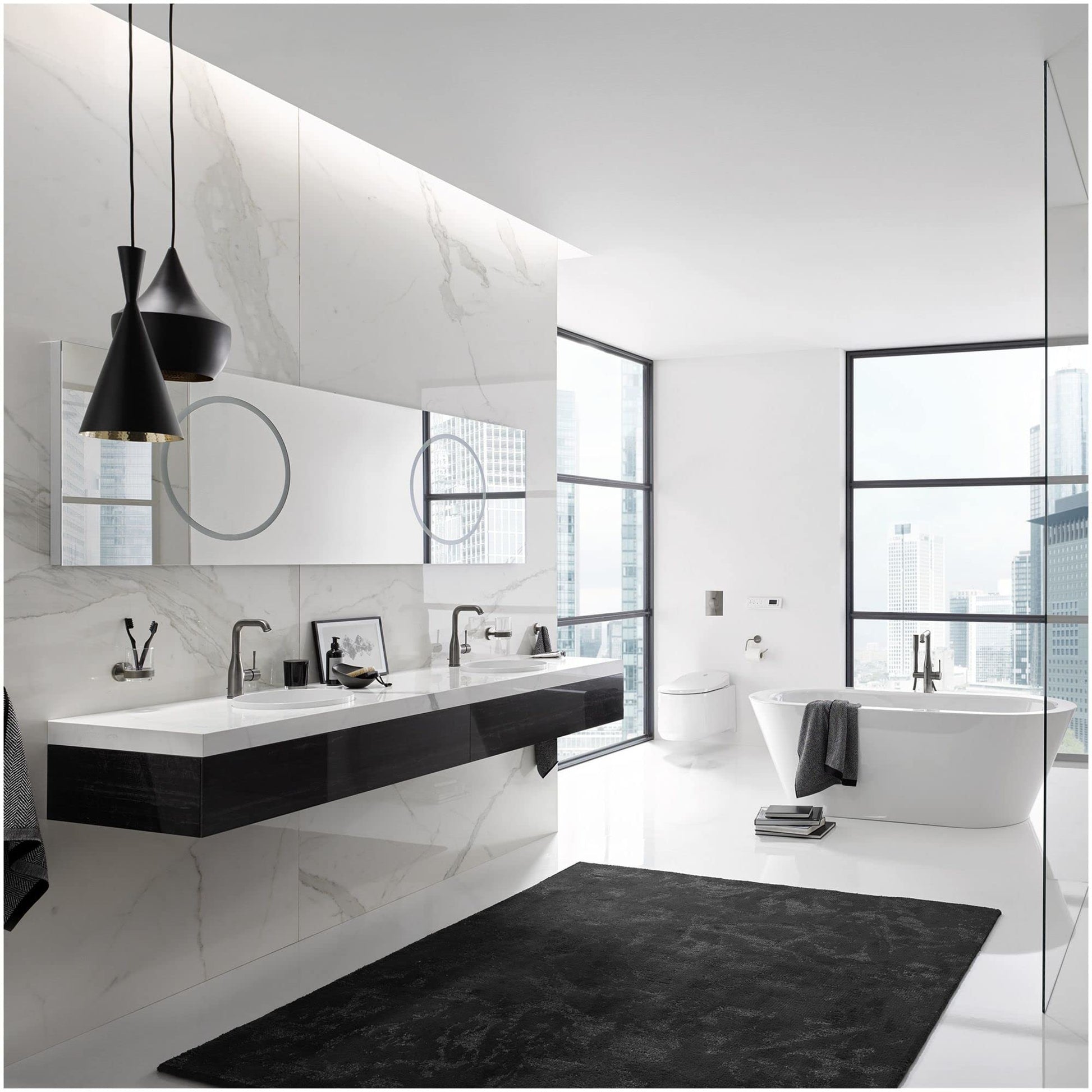 Matte black cylindrical paper holder mounted on bathroom wall next to toilet.