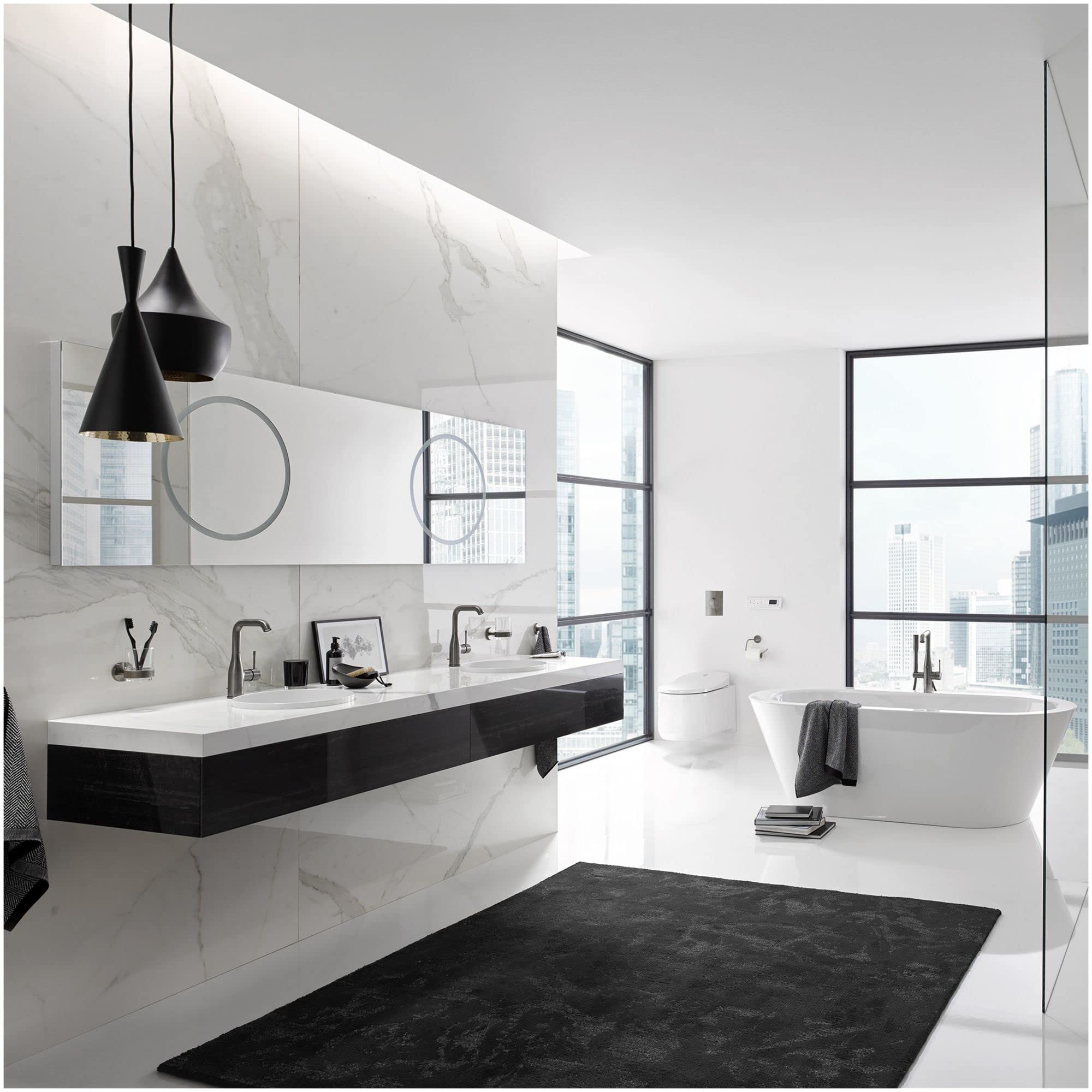 Matte black cylindrical paper holder mounted on bathroom wall next to toilet.