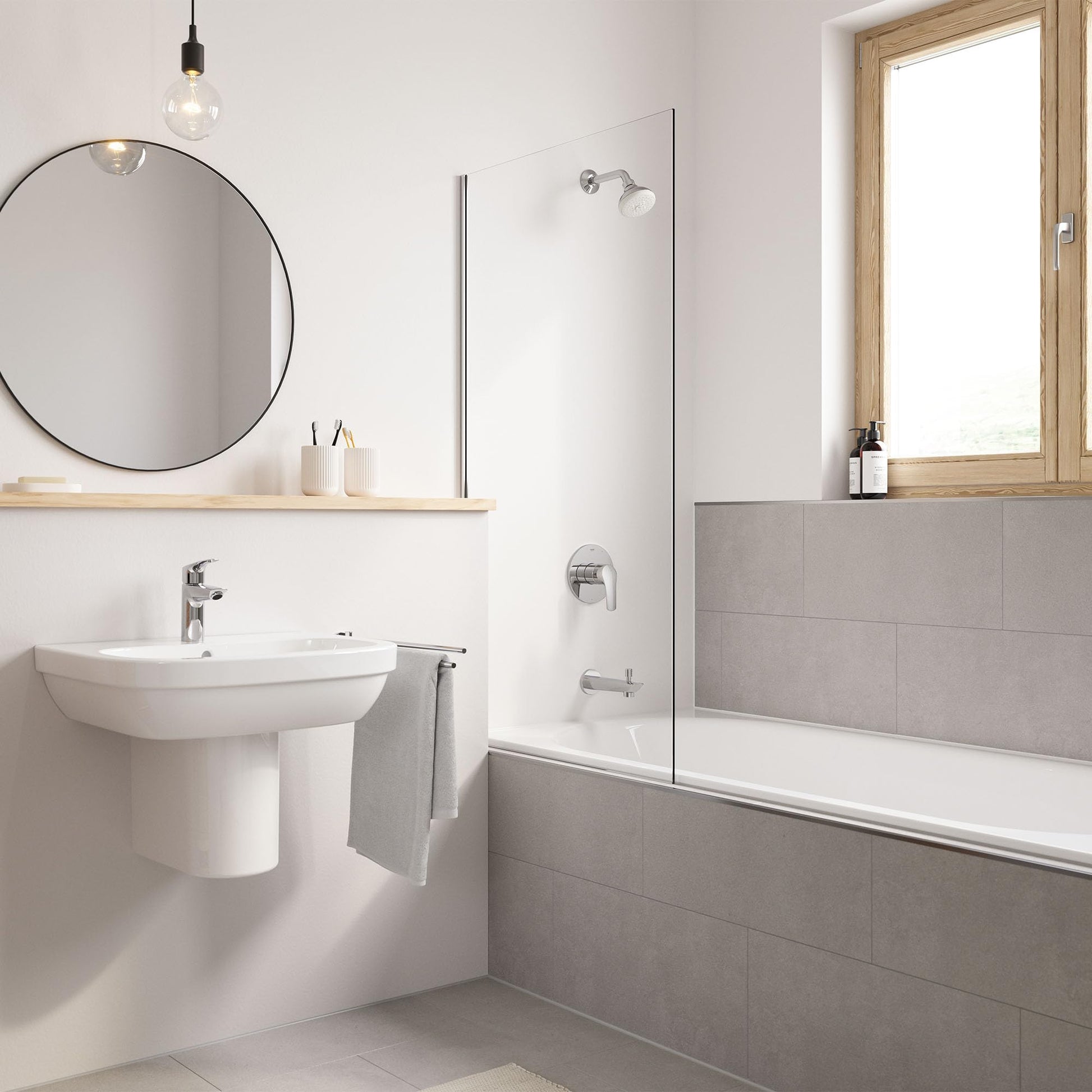 Chrome single-handle bathroom faucet with curved spout installed on white pedestal sink.