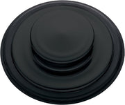 Matte black sink stopper with concentric circular ridges and raised center button.