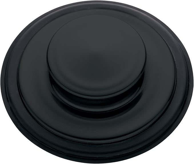 Matte black sink stopper with concentric circular ridges and raised center button.