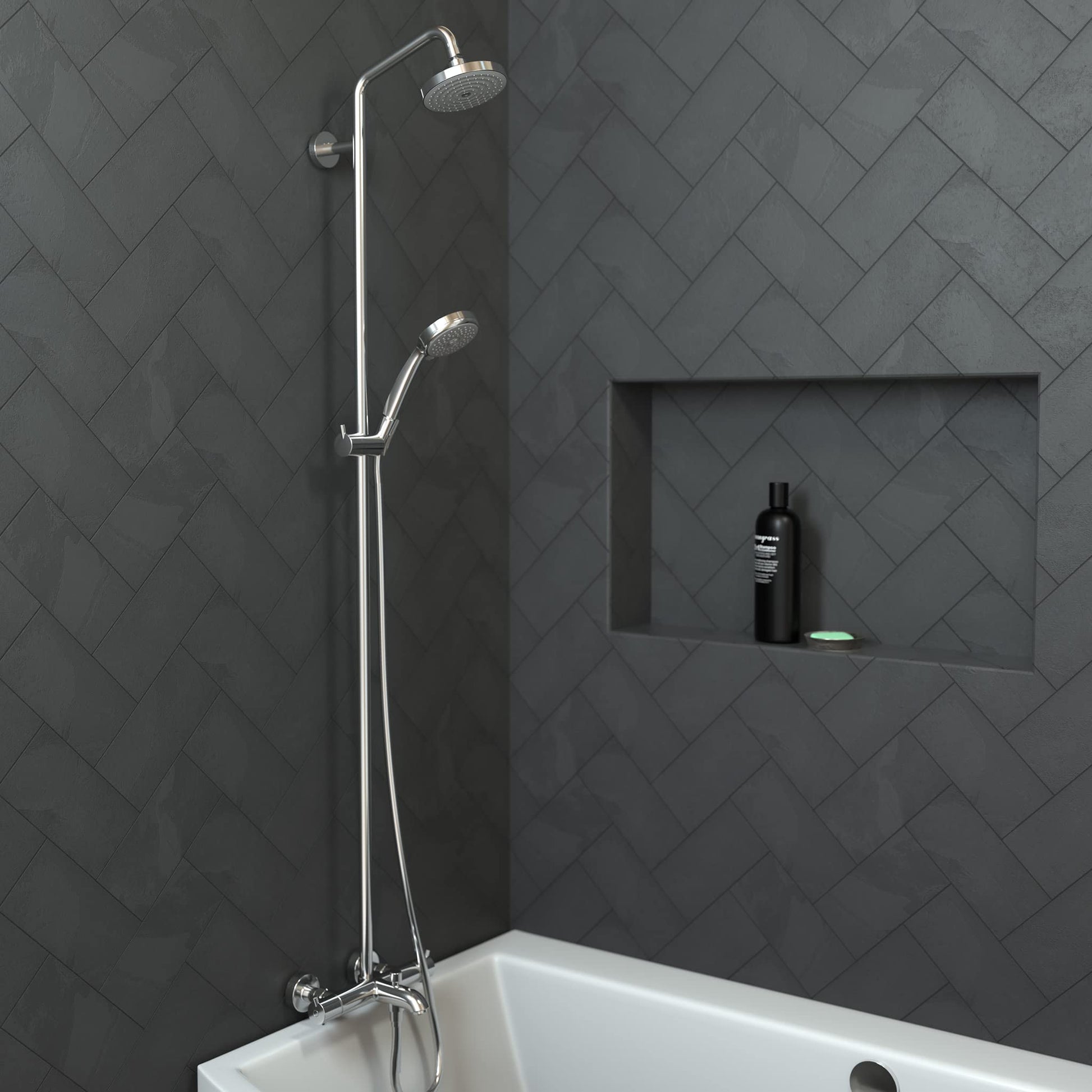 Chrome showerpipe with fixed overhead showerhead and handheld spray mounted above white bathtub against herringbone tile wall