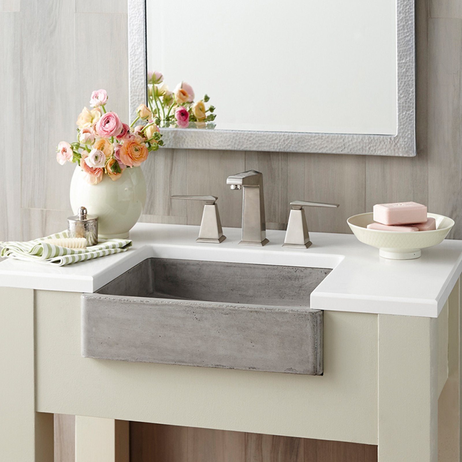 Slate-colored concrete farmhouse sink with white countertop and chrome faucet in bathroom vanity setting.