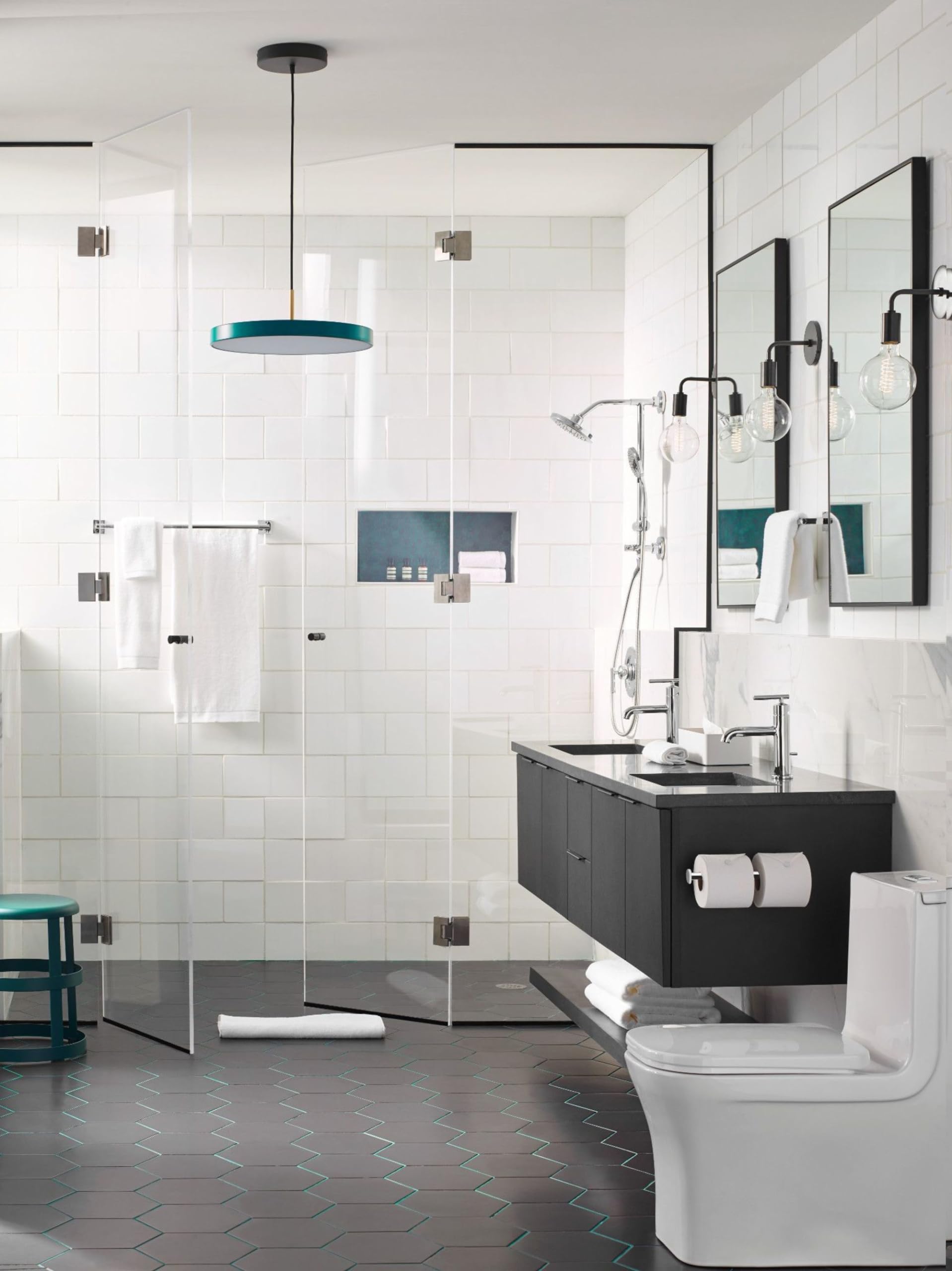 Chrome towel bar mounted on white subway tile wall above black vanity in modern bathroom.
