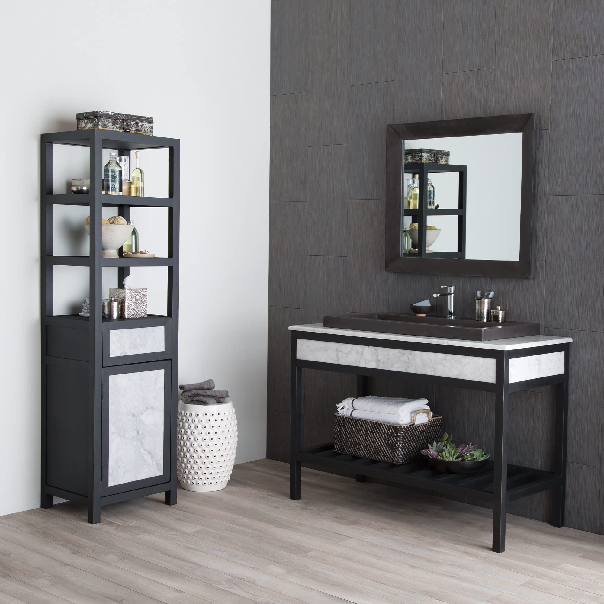 Recessed wall mirror with dark frame and pearl-colored inset panel above black bathroom vanity with white countertop.