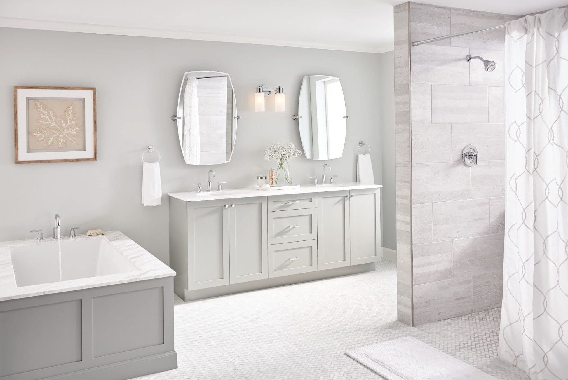 Chrome two-handle deck-mounted Roman tub faucet with modern design installed on bathtub in bathroom setting.