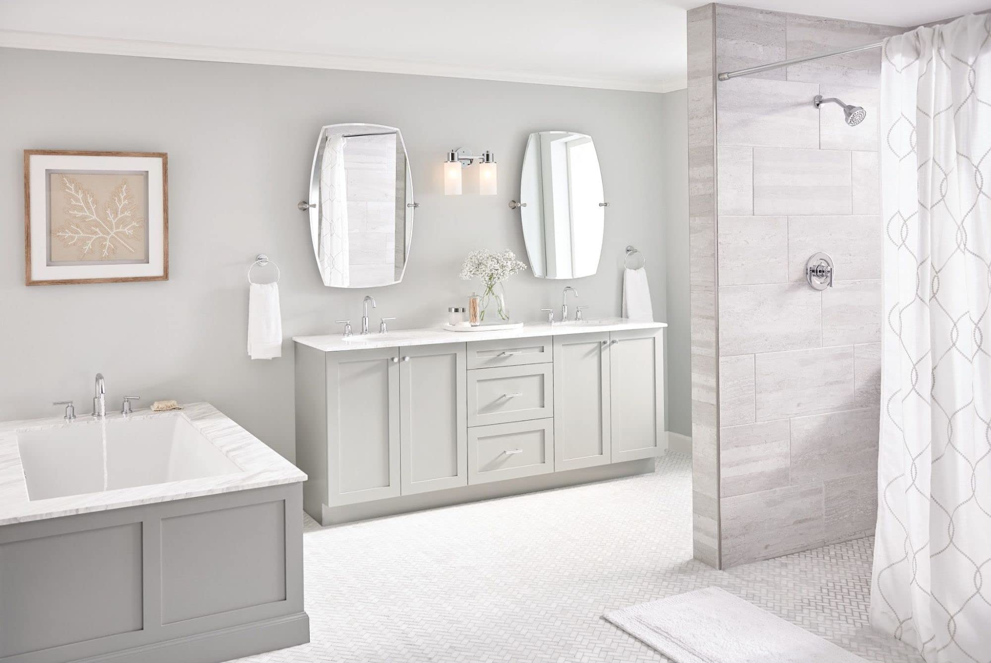 Chrome two-handle deck-mounted Roman tub faucet with modern design installed on bathtub in bathroom setting.