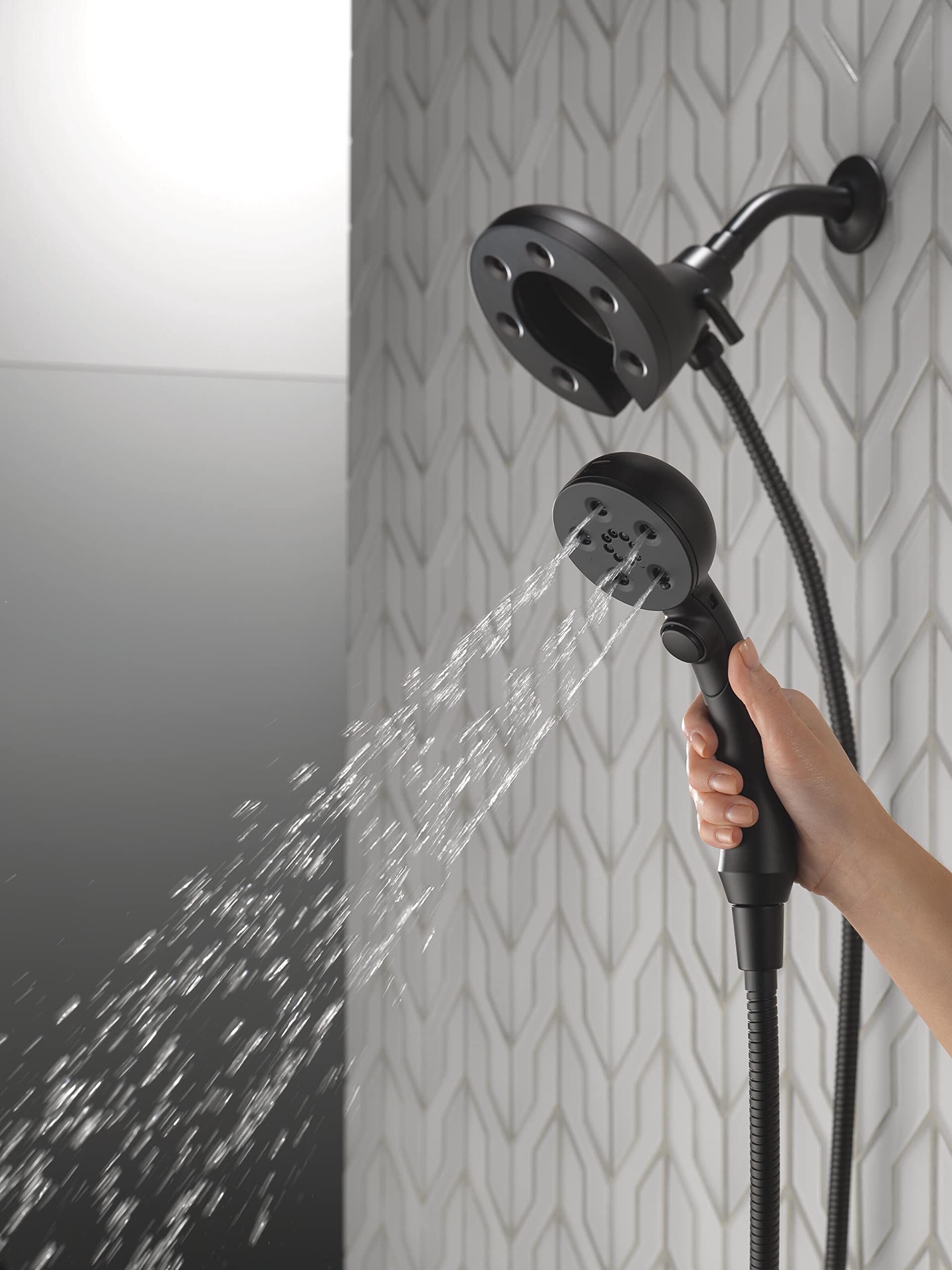 Matte black two-in-one shower system with fixed overhead head and handheld spray head with hose, both dispensing water.