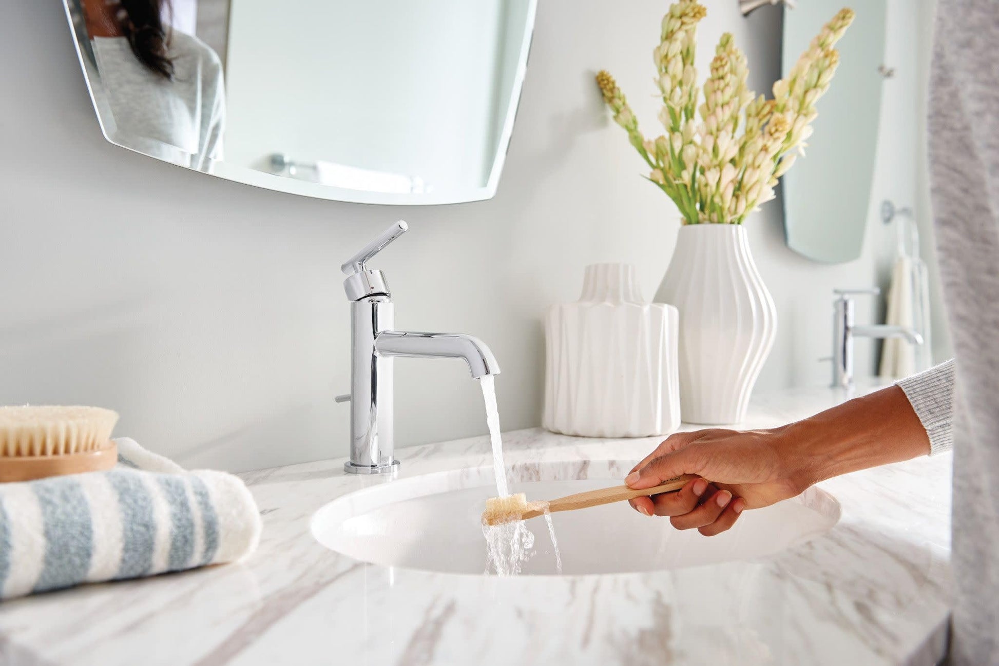 Chrome single-handle bathroom faucet with angled spout installed on marble vanity sink.