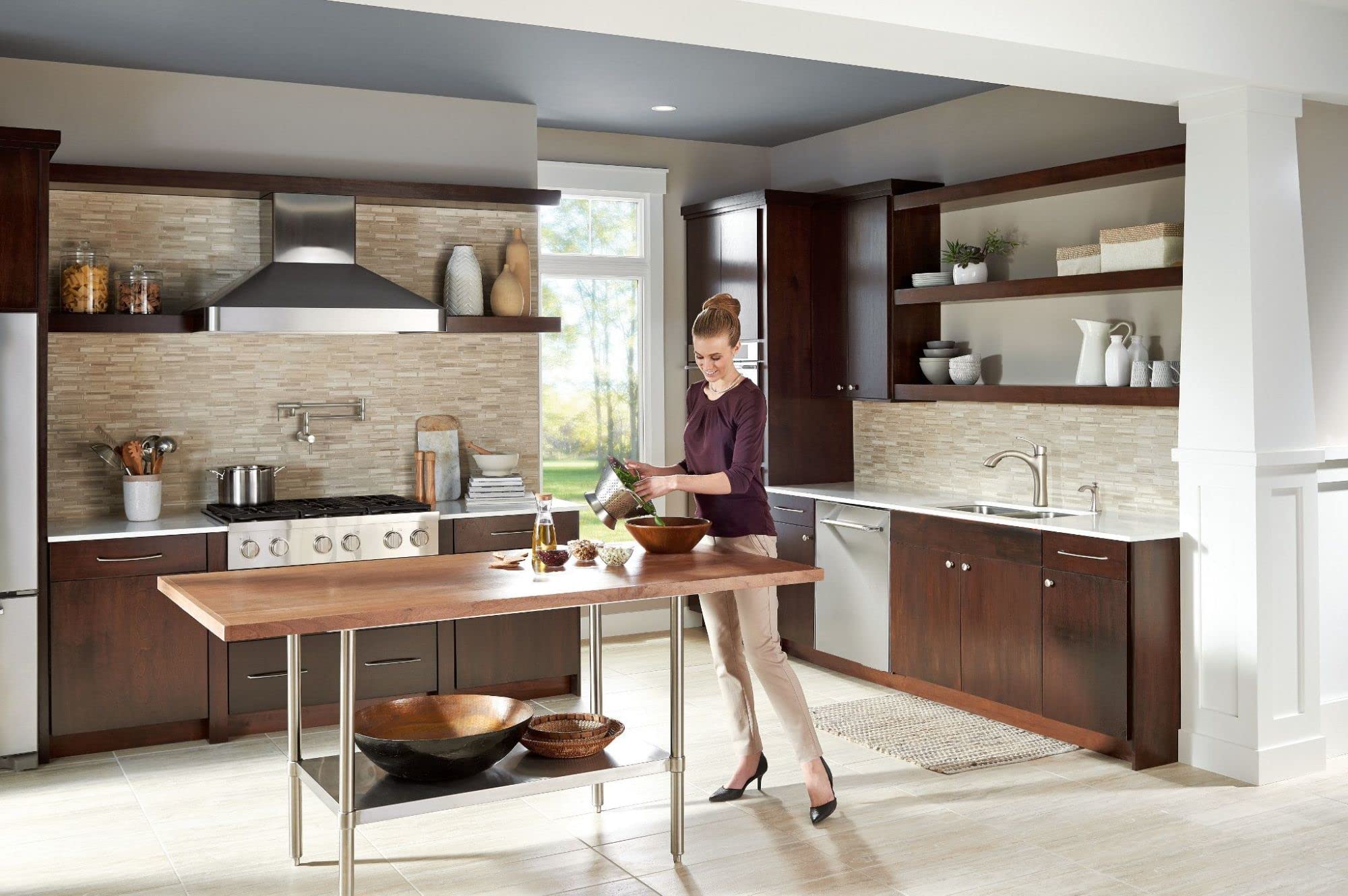 Stainless steel soap dispenser mounted on kitchen sink countertop in transitional kitchen setting.
