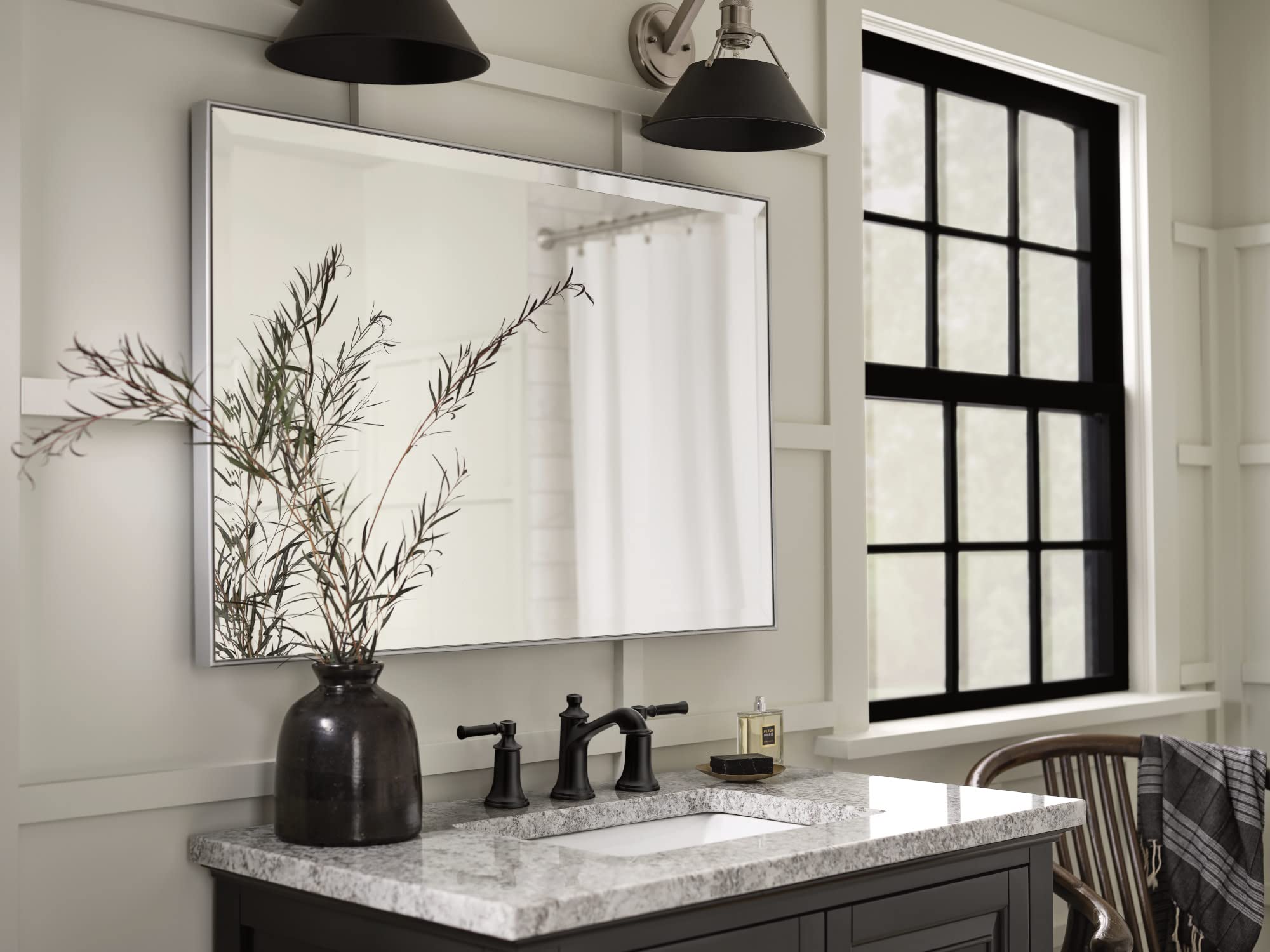 Matte black two-handle high-arc bathroom sink faucet with widespread mounting on marble countertop.