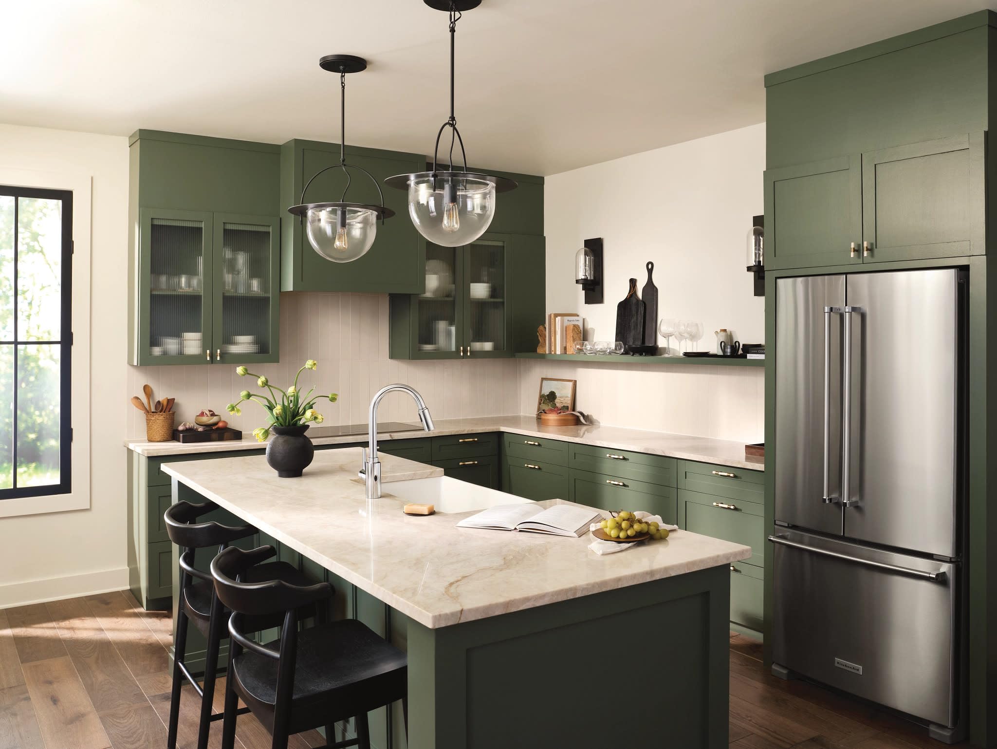 Chrome high arc pulldown kitchen faucet with touchless wave sensor mounted on marble island countertop.