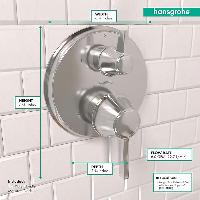 Chrome round thermostatic shower trim with two control knobs mounted on white subway tile, 6⅝ inches wide.