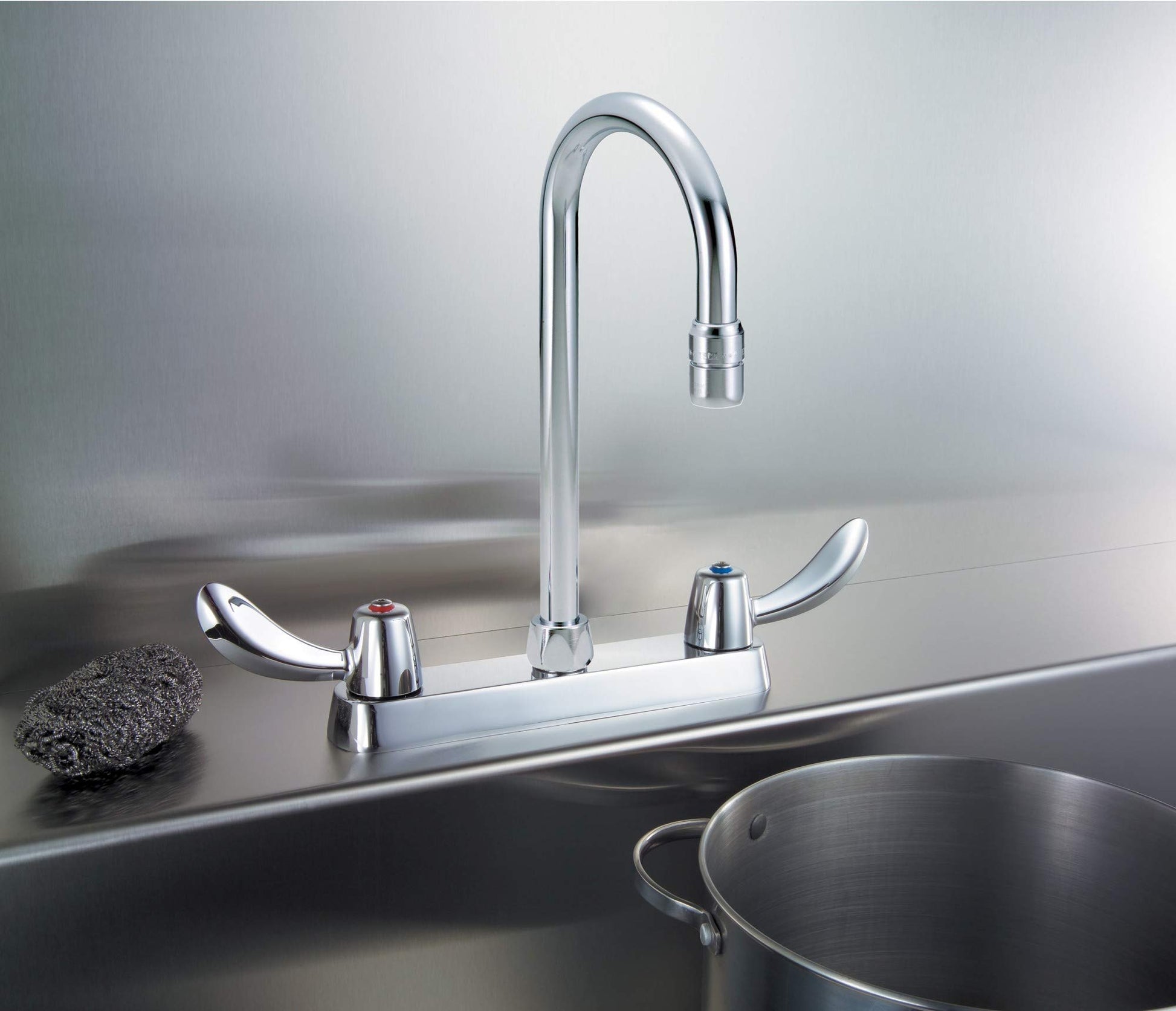 Chrome two-handle deck mount faucet with curved spout and lever handles on stainless steel sink.